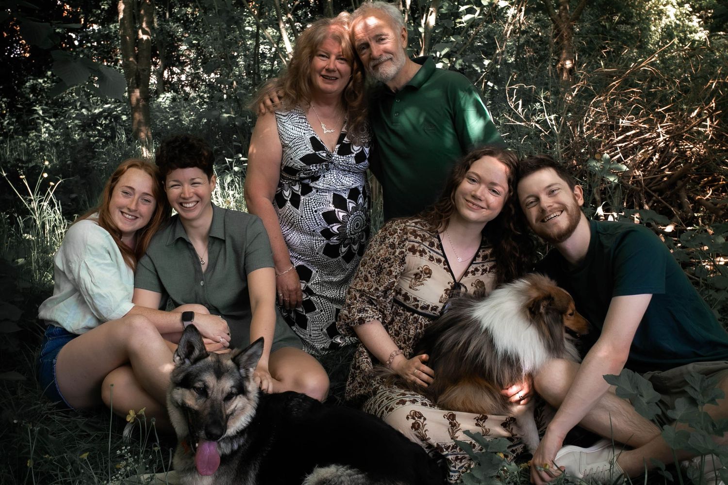 Family of six and their two dogs smiling at the camera at their family home garden in Leicester