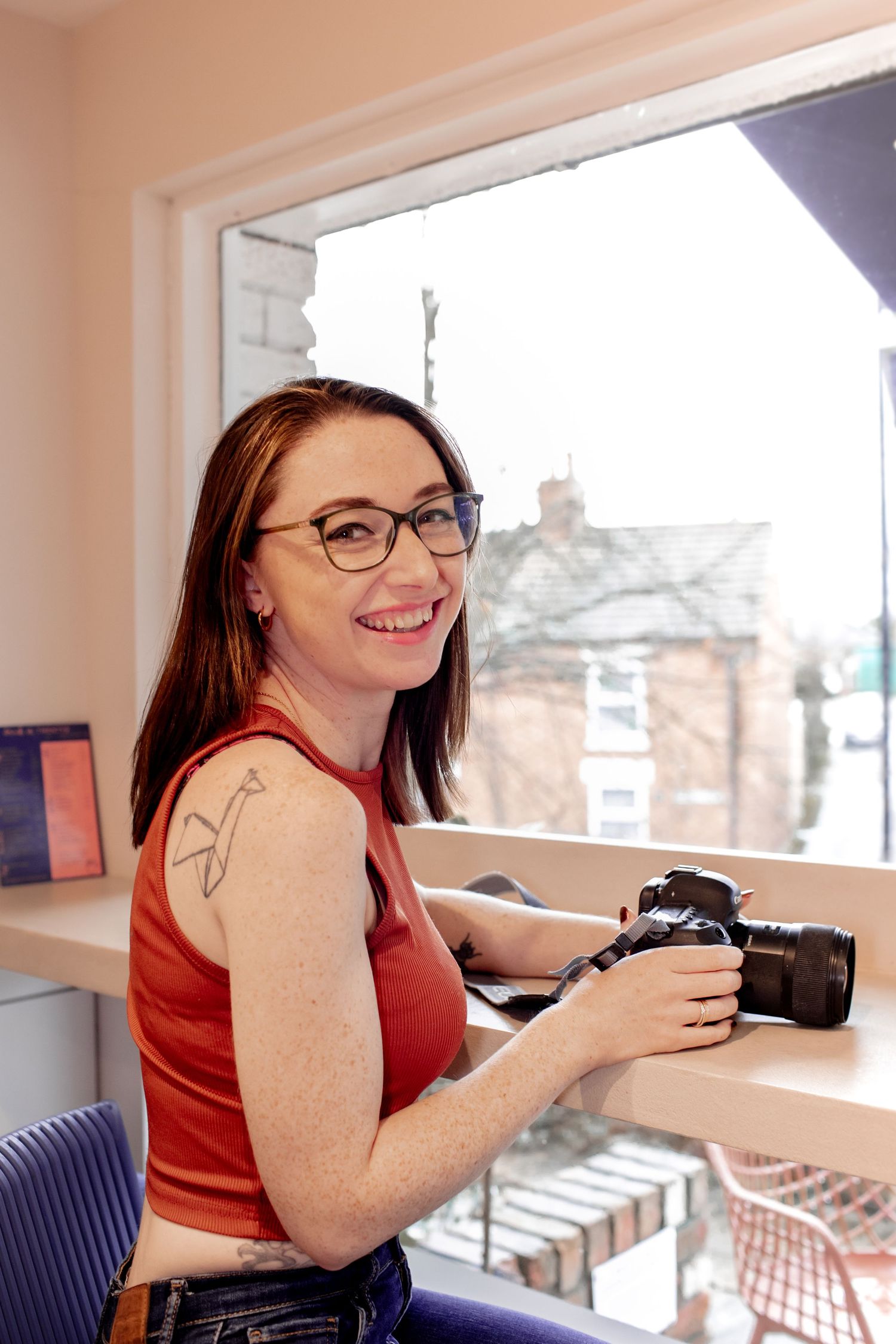 Katie Finn Photography looking into camera smiling whilst holding her camera