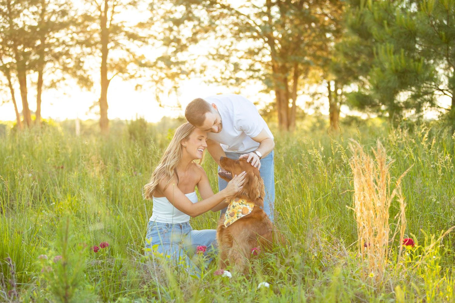 A family and their golden retriever share a tender moment in a sunlit meadow during golden hour.