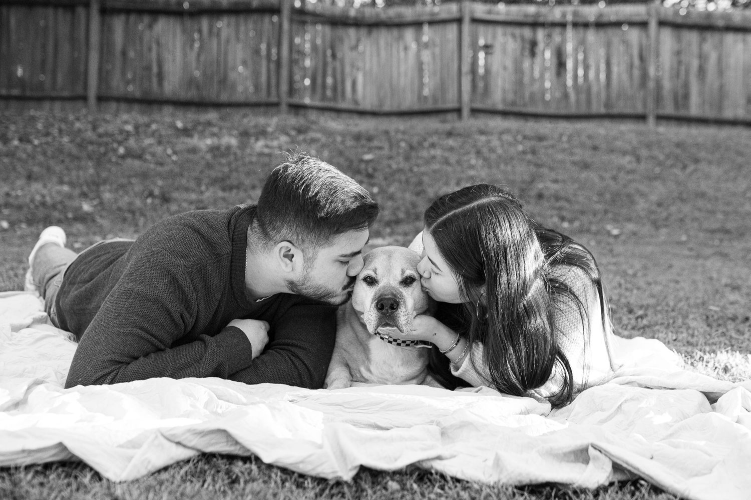 Couple lying together on a blanket in black and white romantic photo series.
