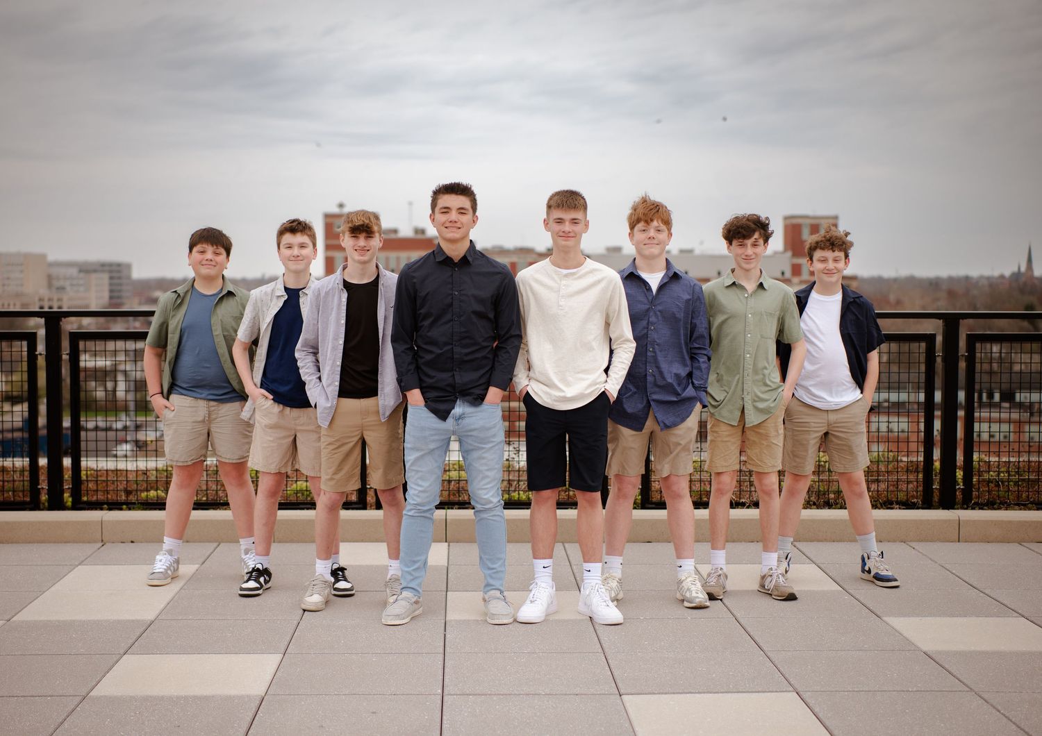 A sequential panoramic photo series showing a group of people in casual attire standing against a wall outdoors.