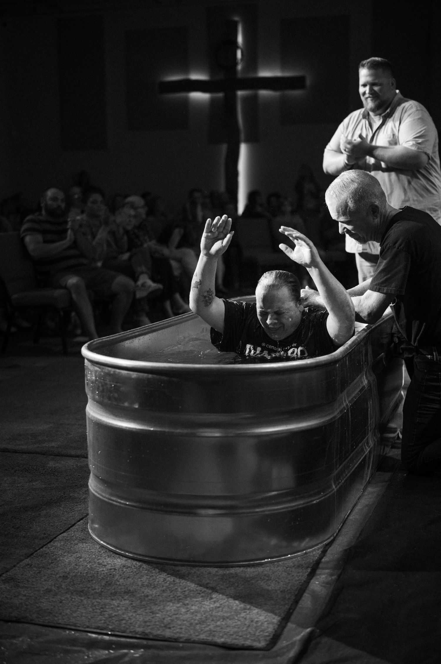 High intensity CrossFit workout sequence showing athlete flipping large tire in a dark gym setting.