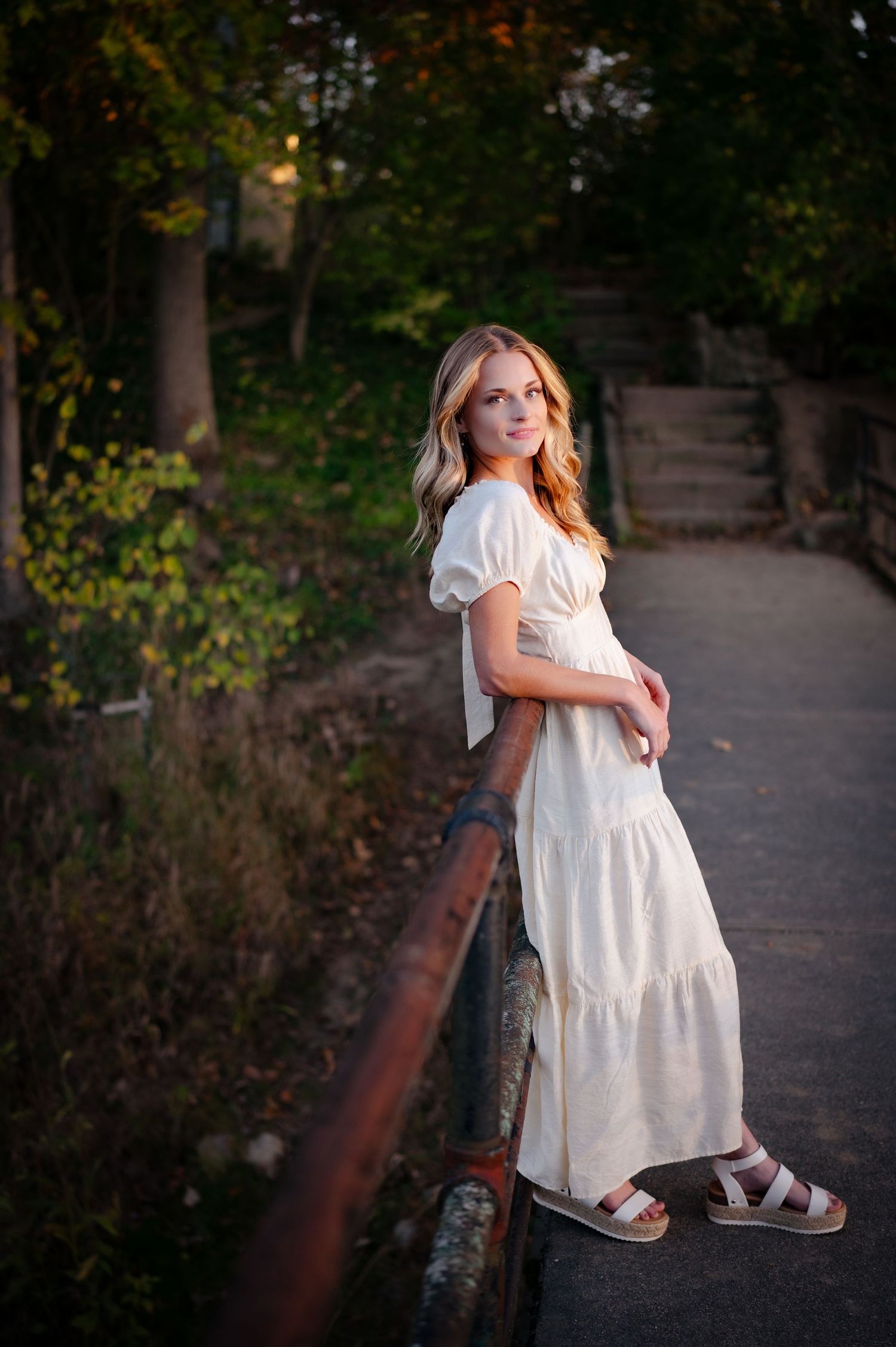 A white flowy dress portrait on a park path during golden hour.