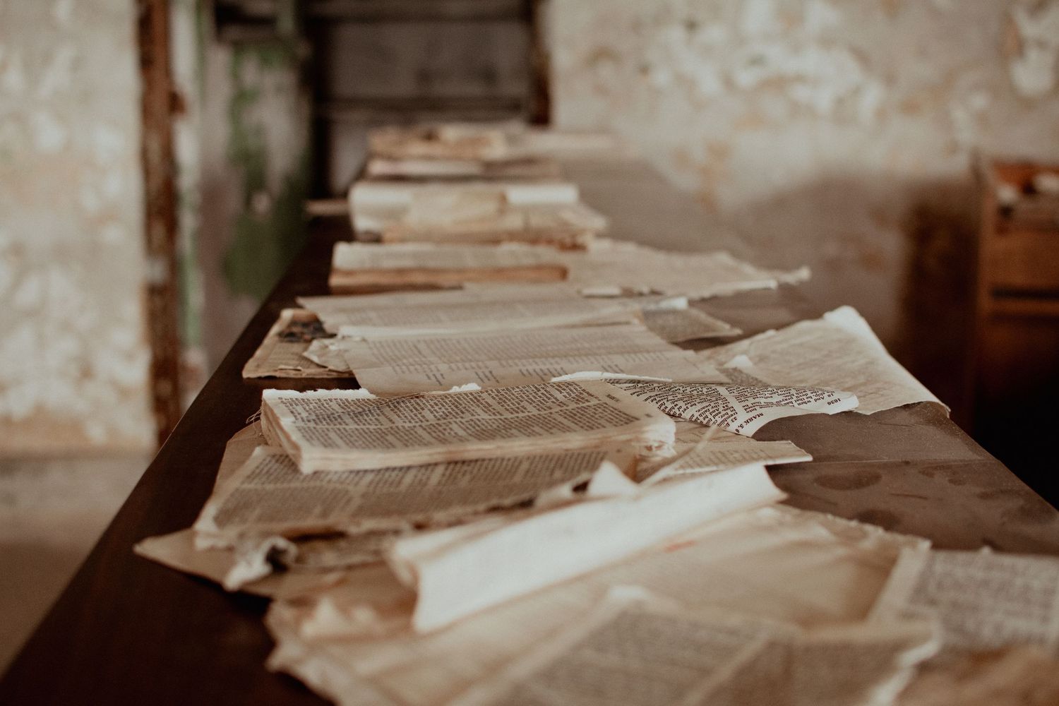 Old weathered papers and documents spread across a wooden table in sepia tones.