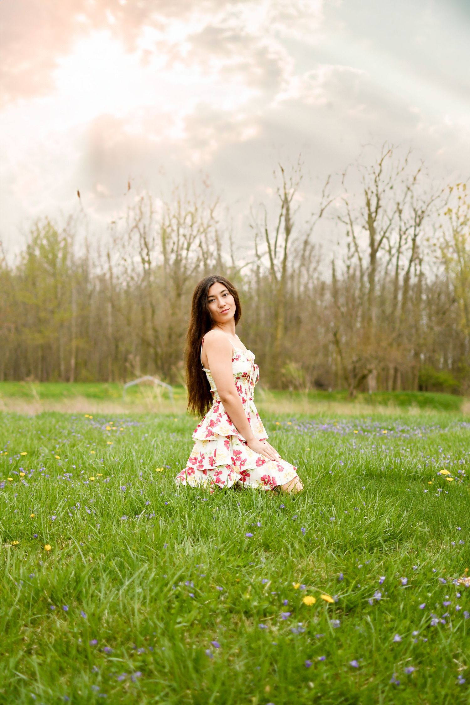 A floral dress portrait in a spring meadow with blooming wildflowers.