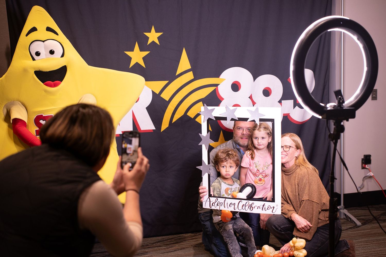 Photo setup with large yellow star mascot and ring light in studio for taking pictures.