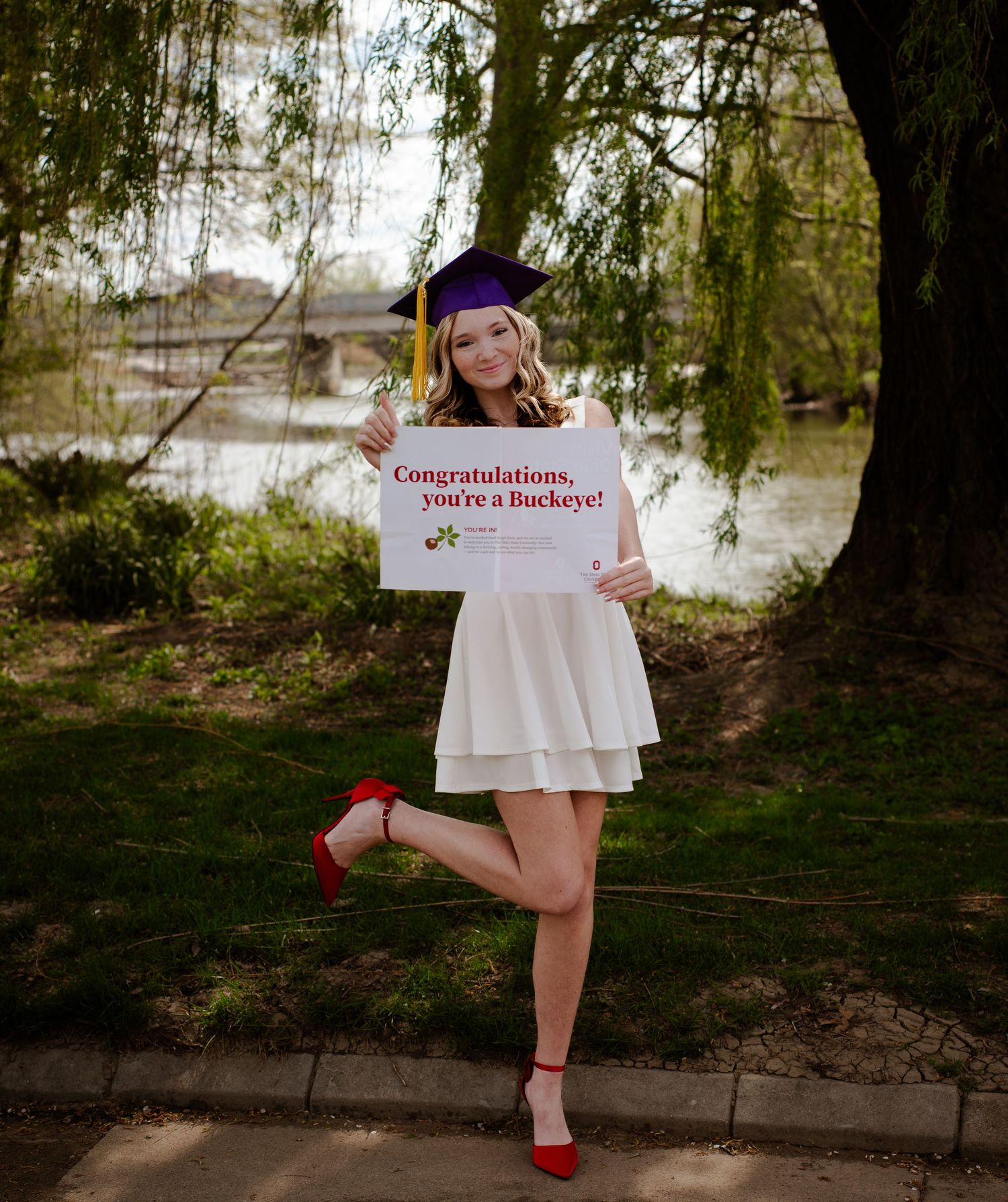 A graduation photo series showing a graduate in red heels posing with a congratulatory sign under a willow tree.
