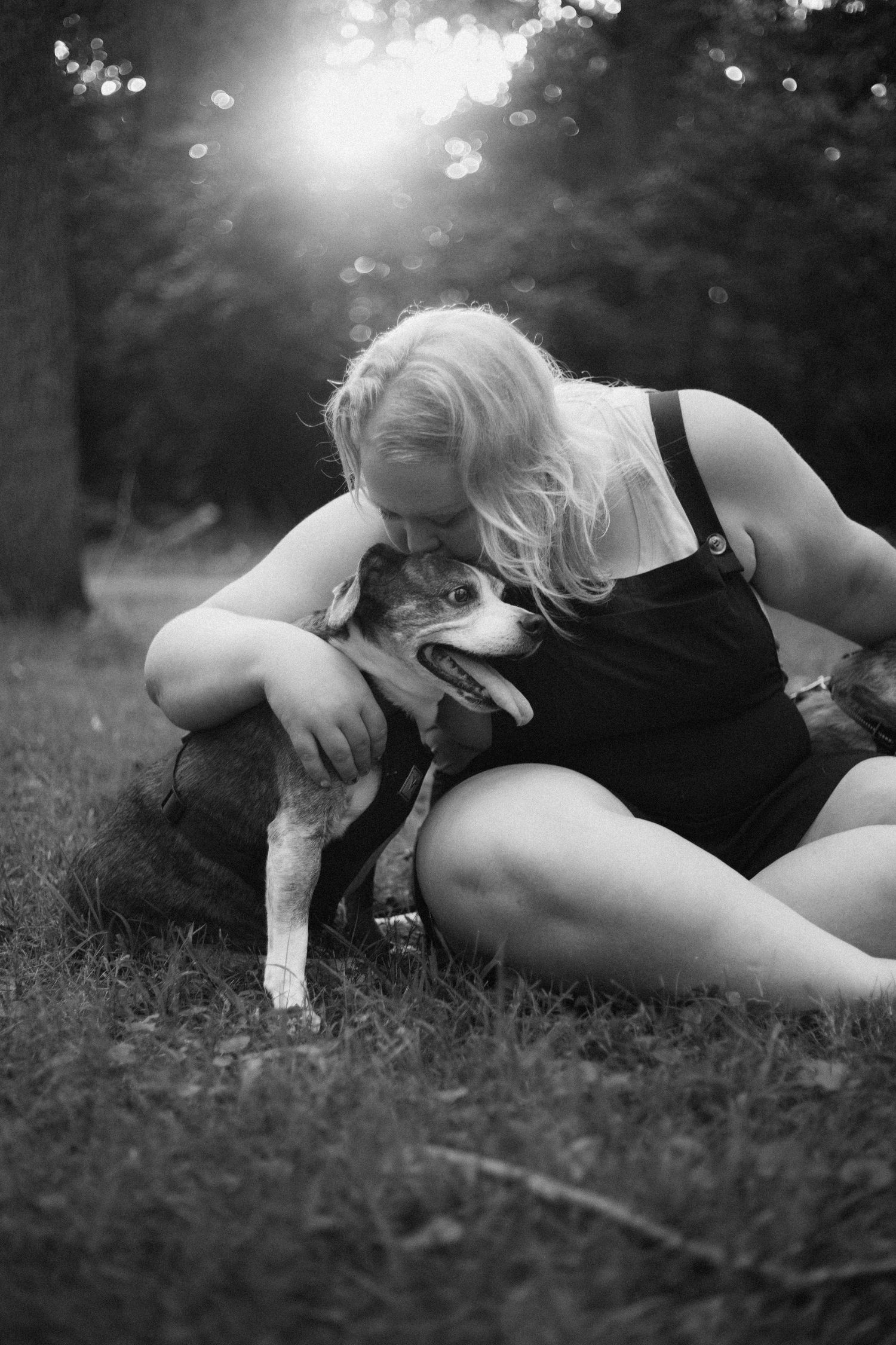 Black and white photo series showing loving moments between person and their dog on grass.
