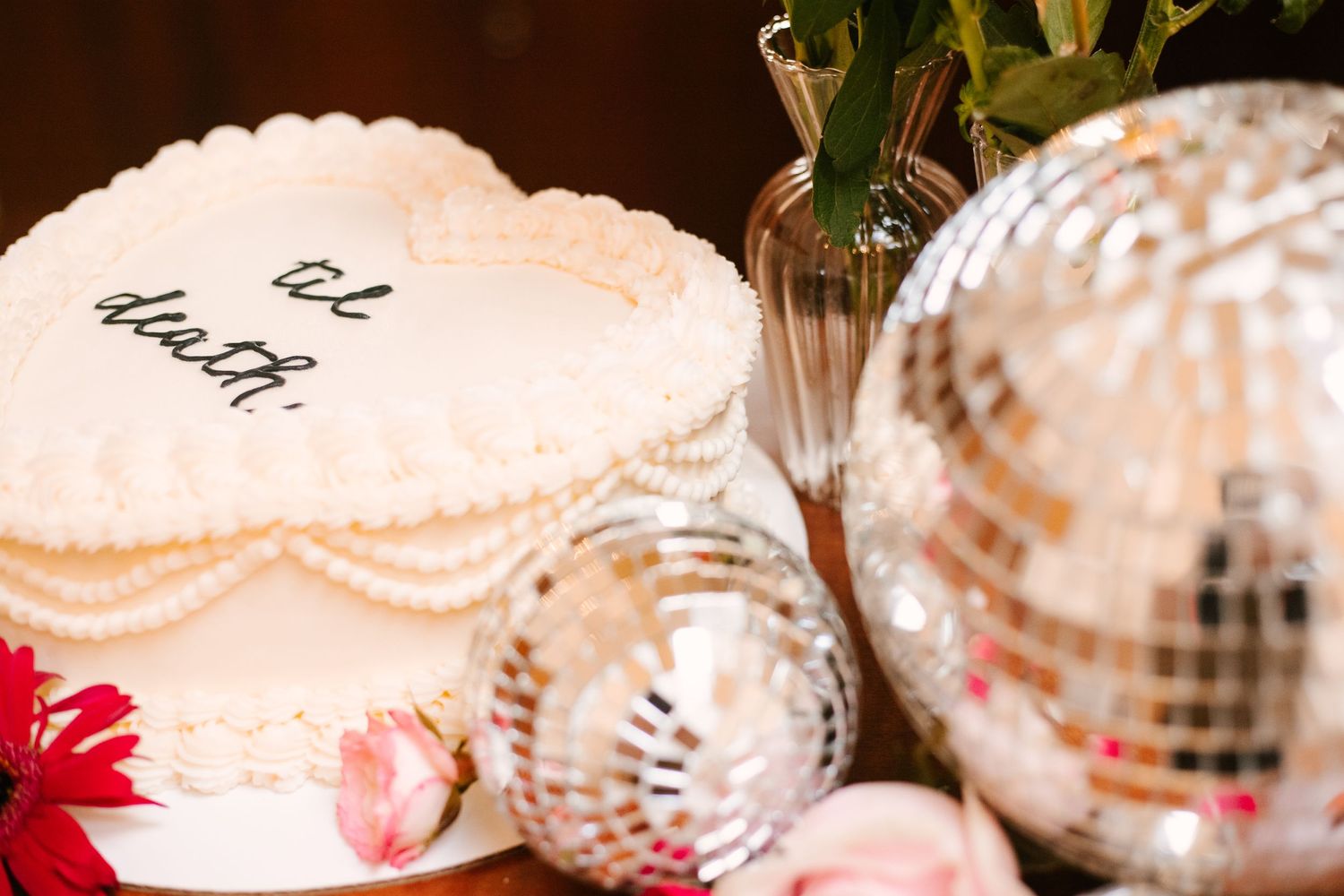 Delicate white floral decorations and disco balls create an elegant wedding reception display.