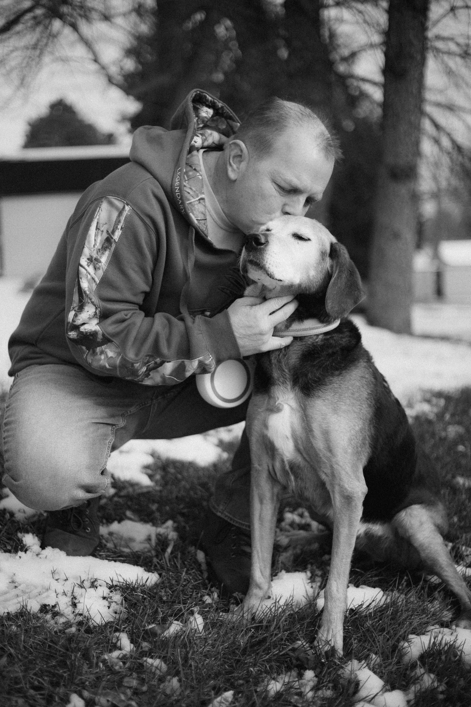 A person shares intimate moments with their dog outdoors in black and white photographs.