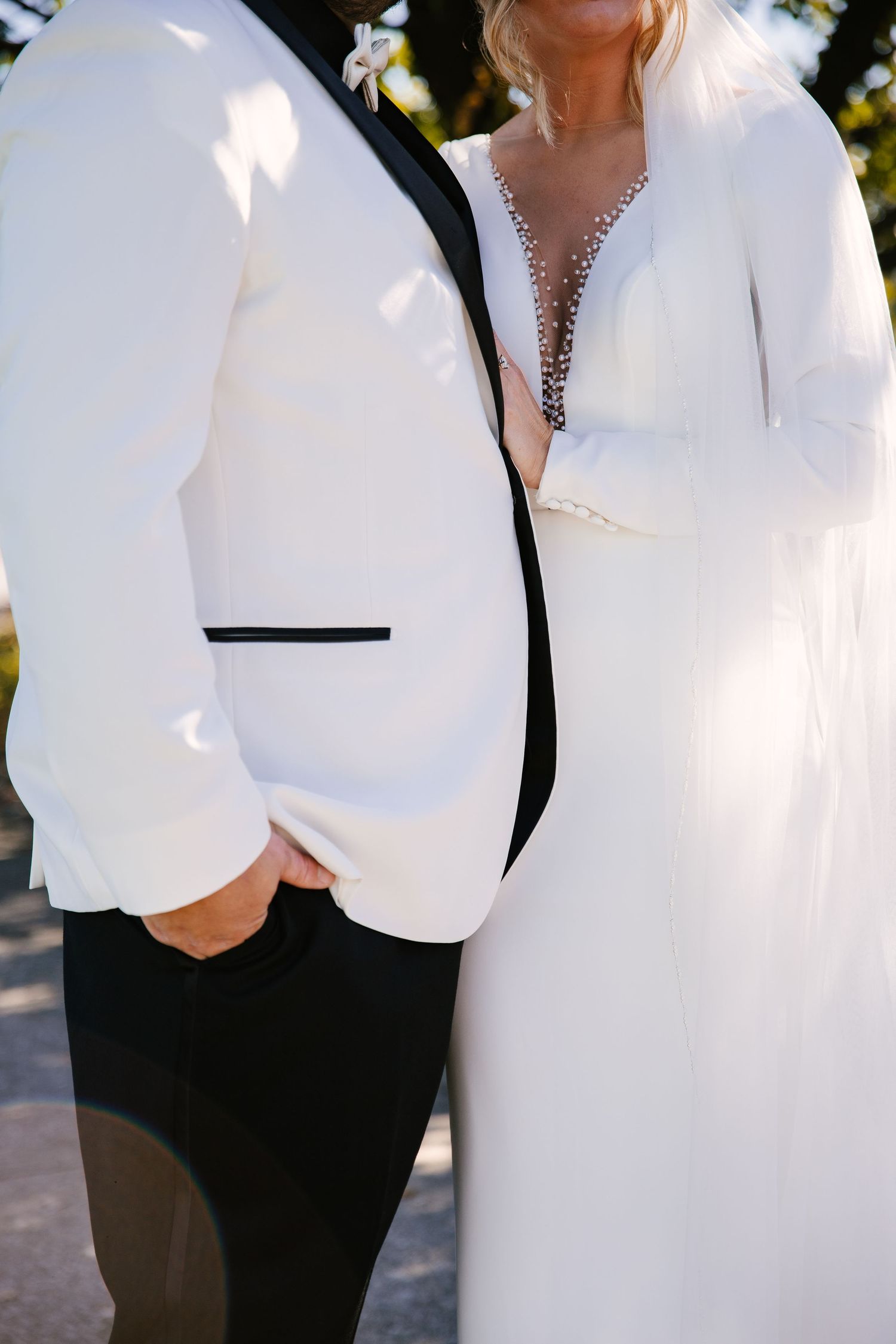 Crisp white formal attire details with elegant jewelry accents.