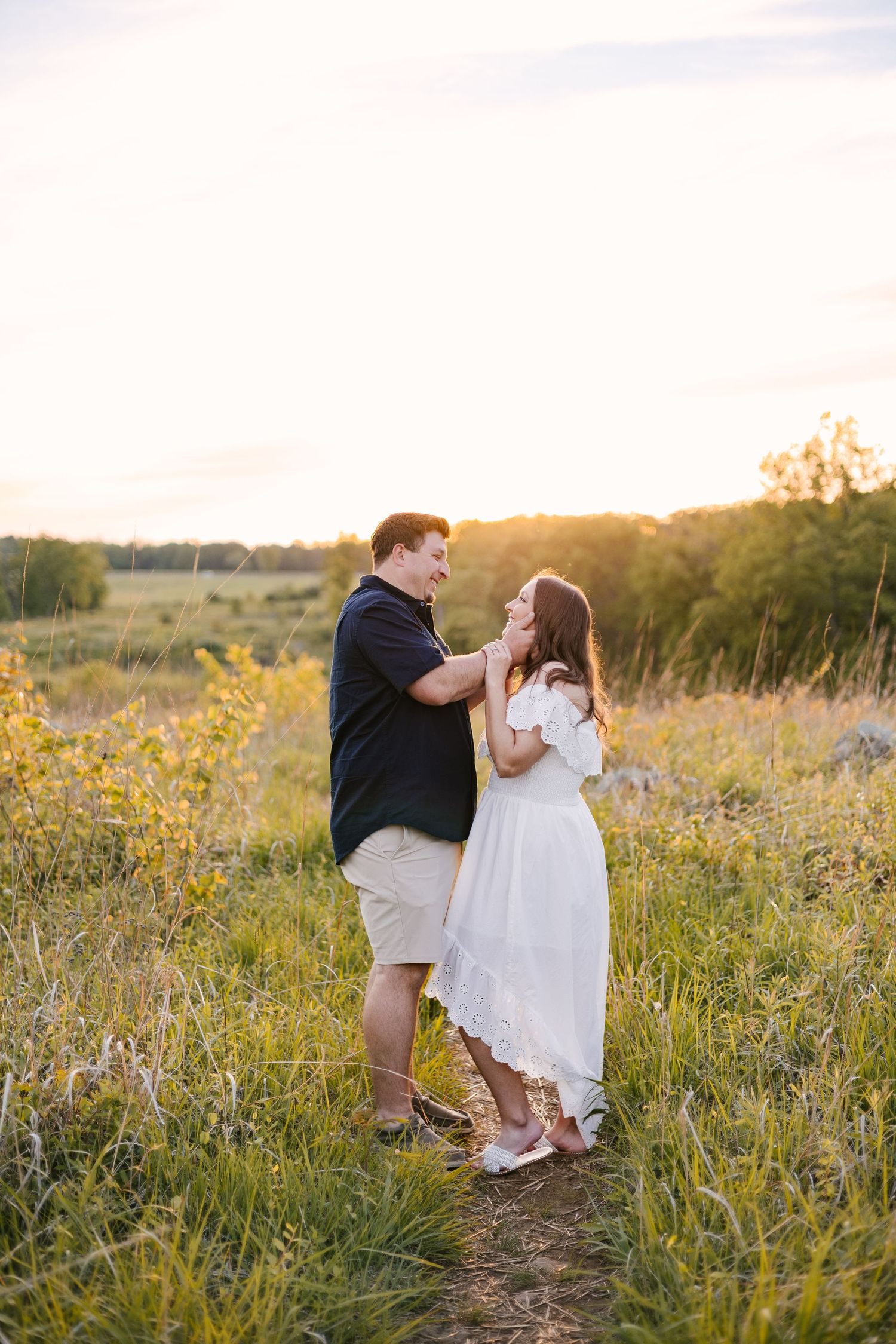 Playful couple dancing together in a wildflower meadow during golden hour.