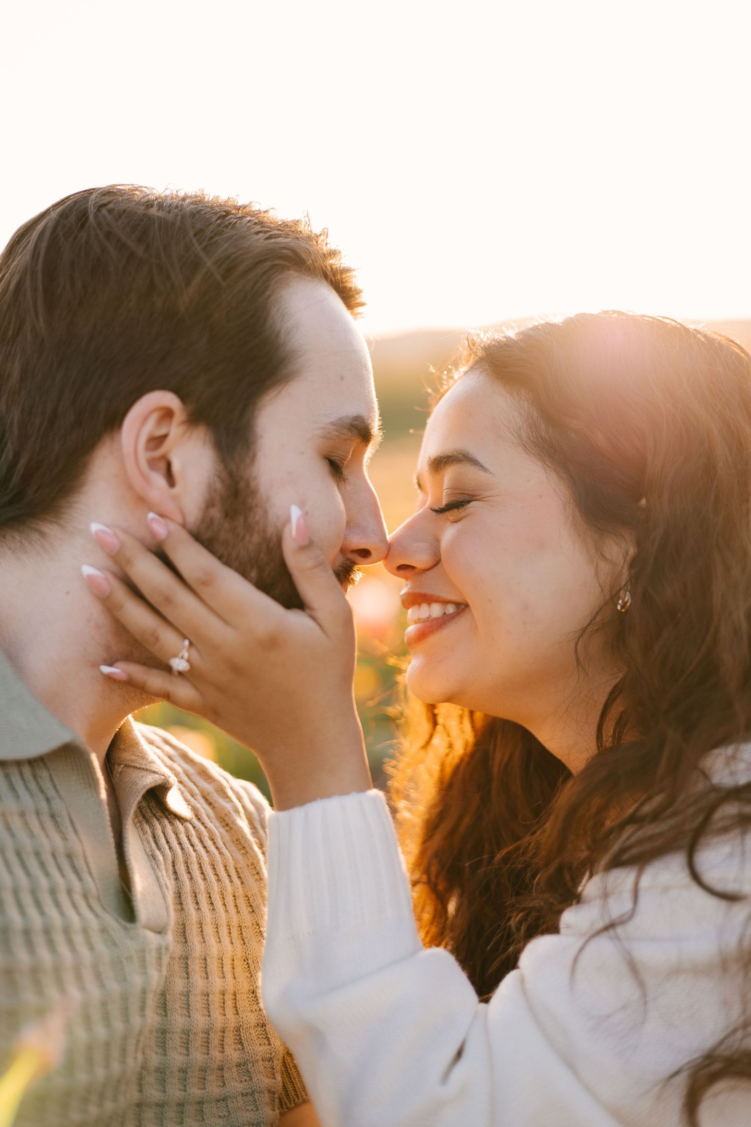 Close-up romantic couple portraits with golden sunlight creating dreamy atmosphere.