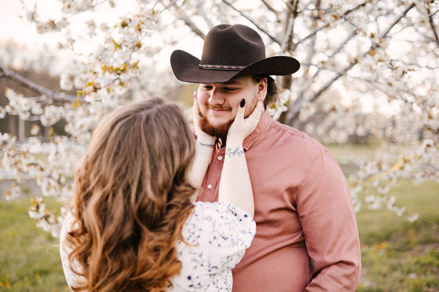 Spring engagement photos among blooming cherry blossoms.