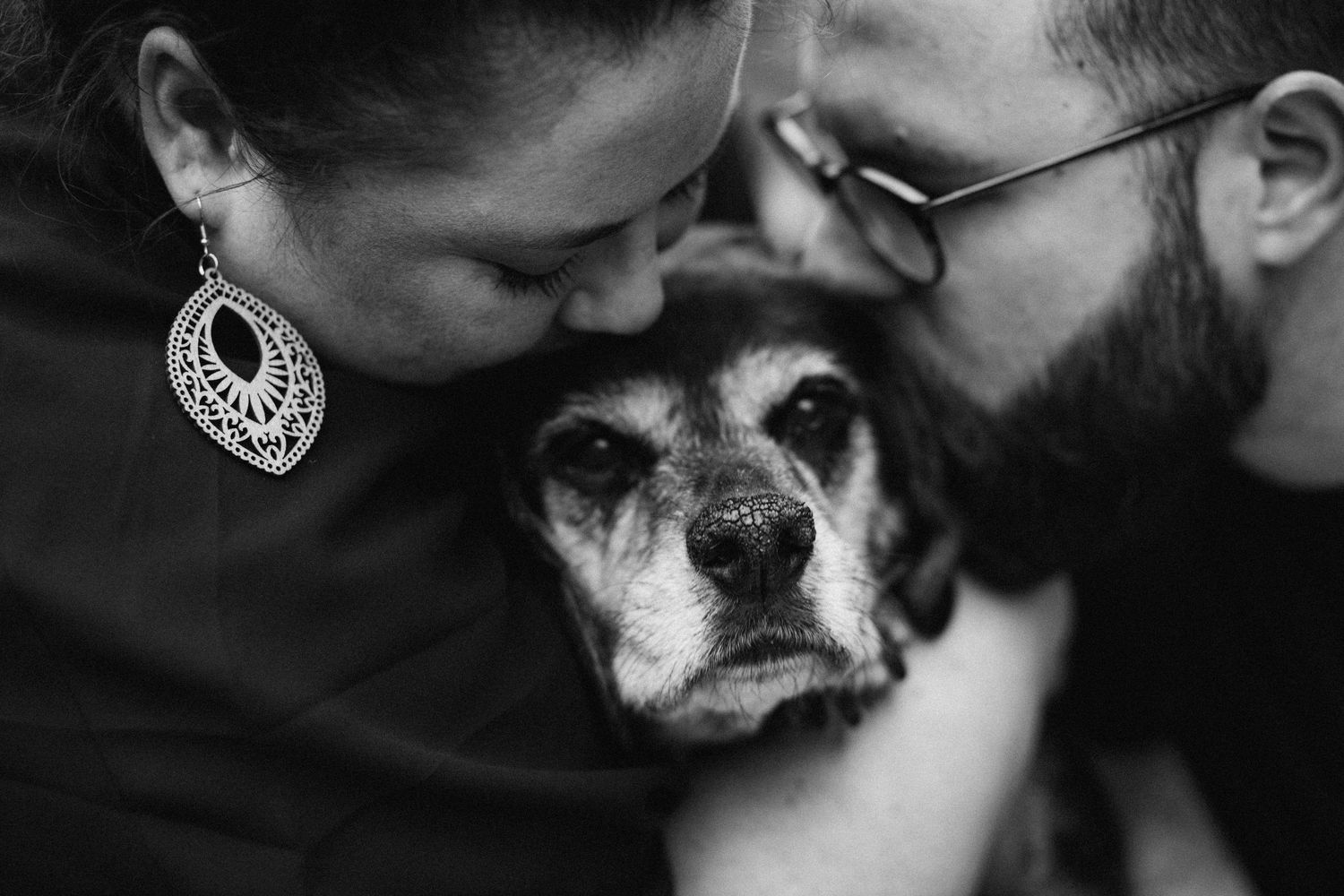 Intimate black and white close-up of person sharing tender moment with their dog.