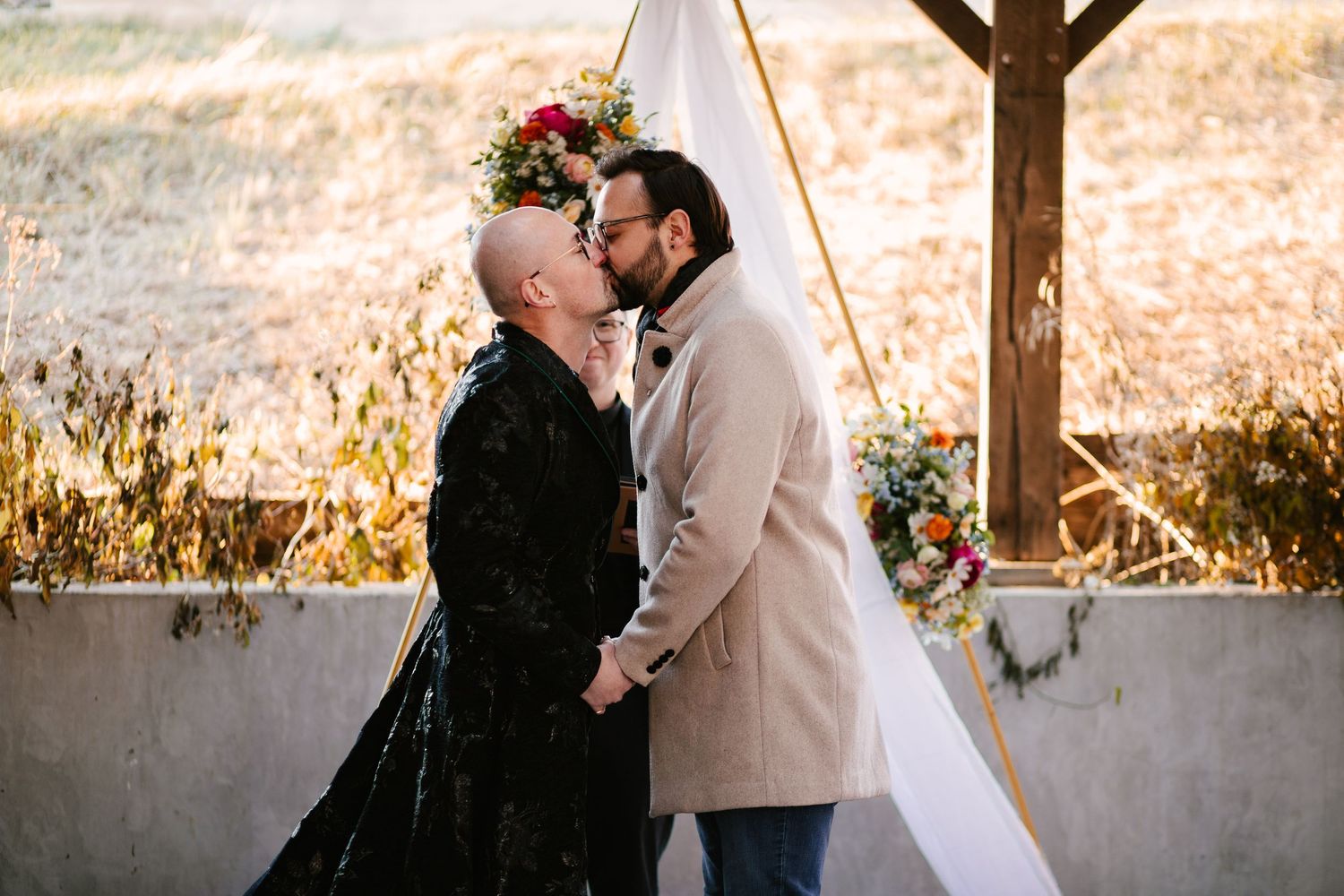 Wedding ceremony moments under a rustic wooden arch with floral decorations.
