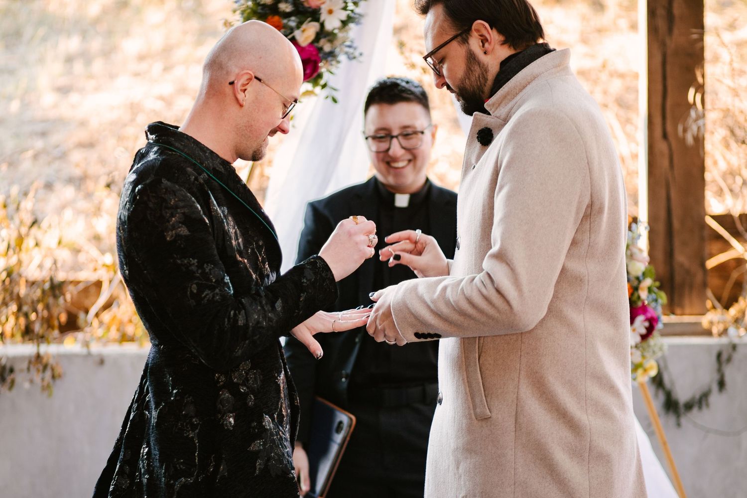 Emotional exchange during wedding ceremony with guests watching in background.
