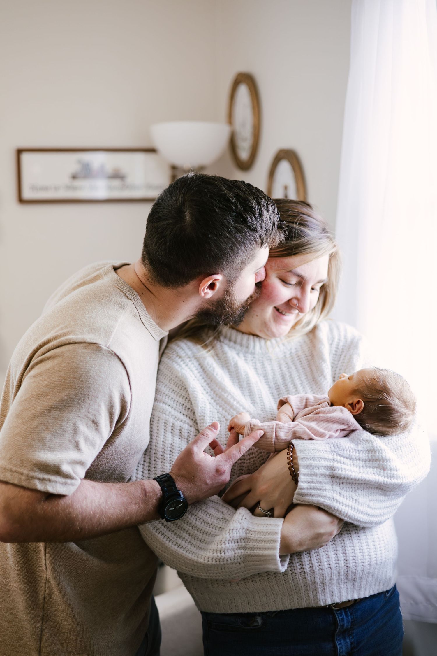 Family sharing tender moments together in a minimalist white room with modern decor.