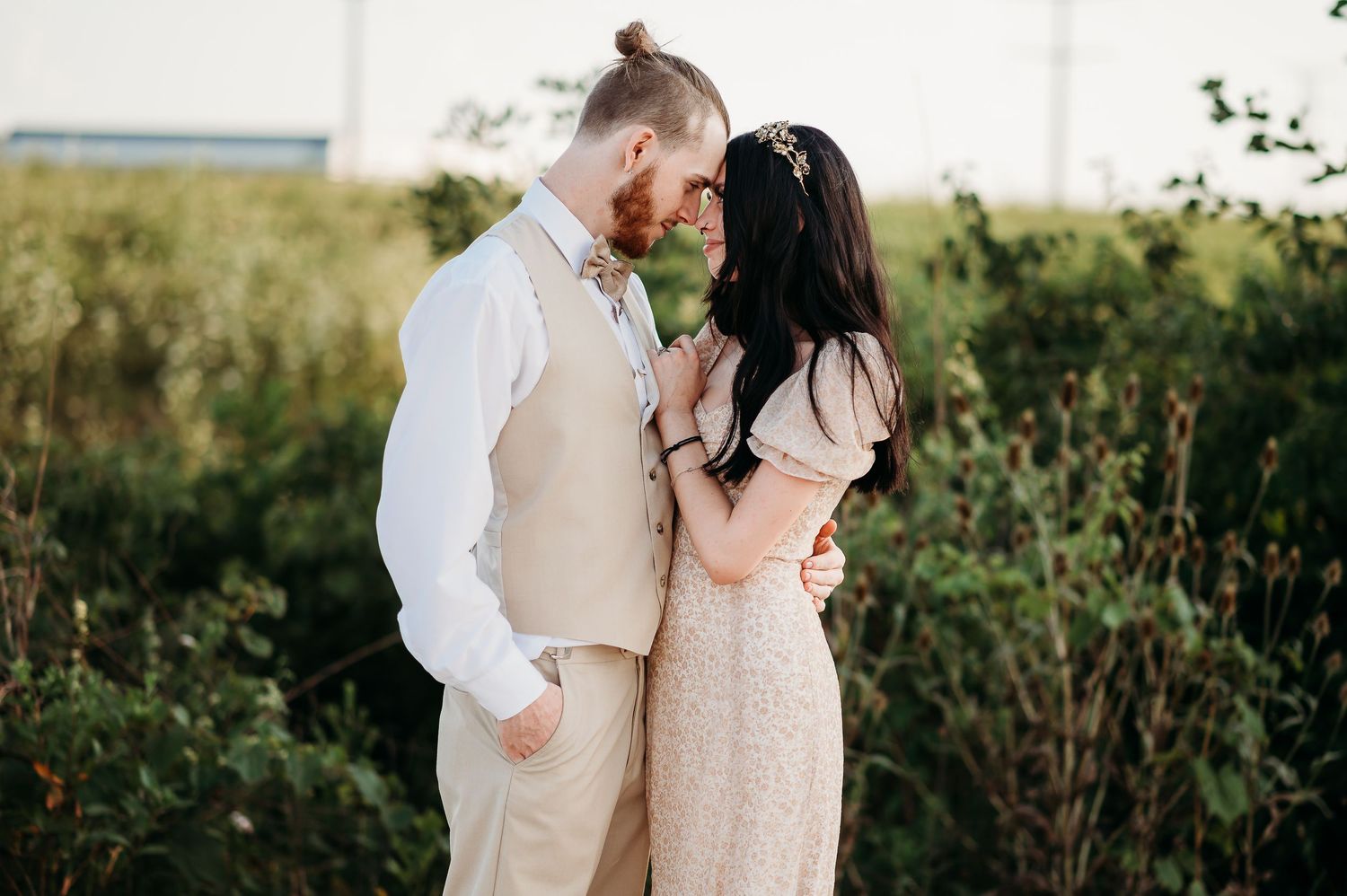 Couple embraces in romantic poses during their outdoor wedding photoshoot.