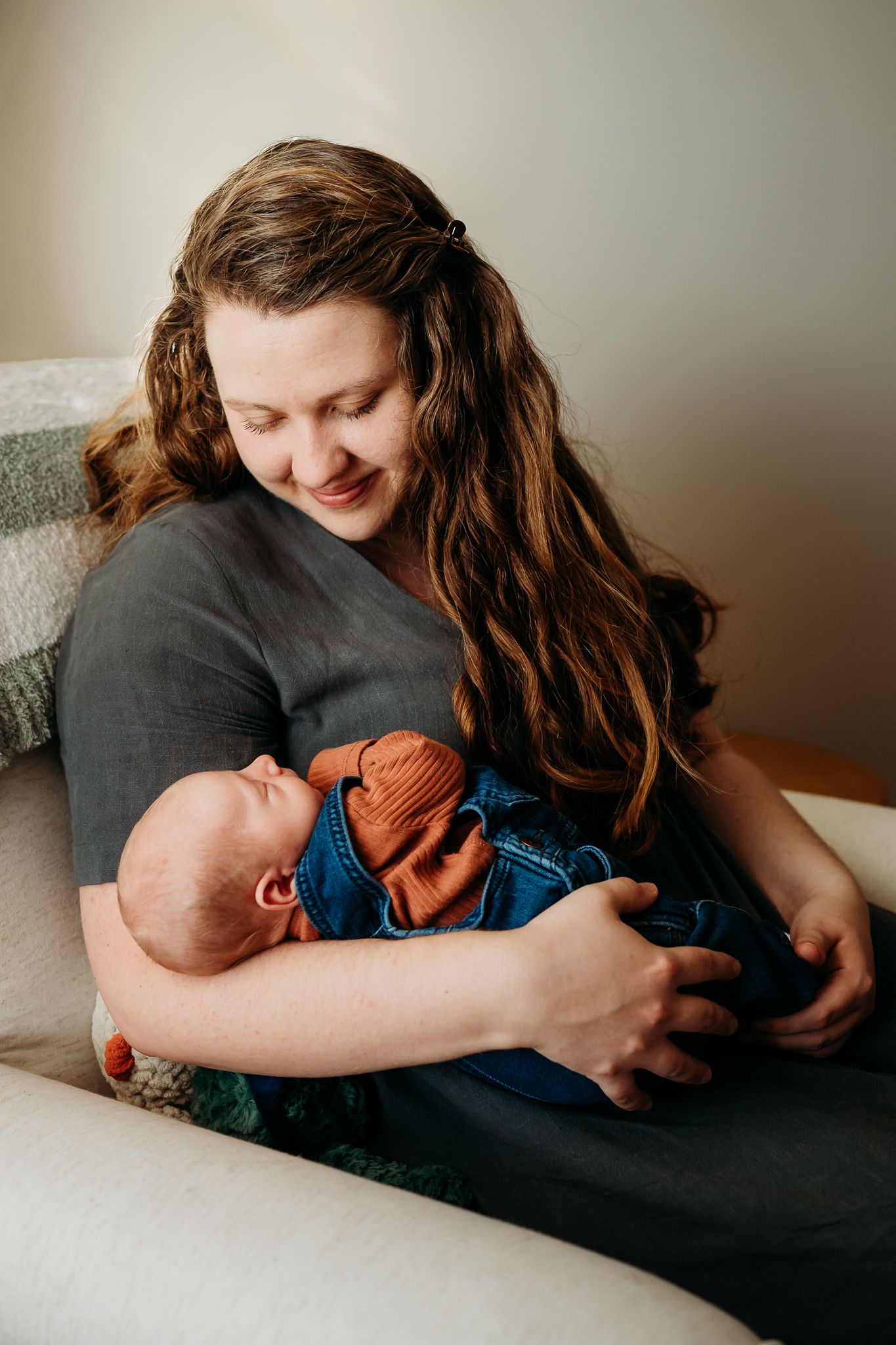 A Greenwood, Indiana, mother cradles baby boy in nursery during newborn photo session.