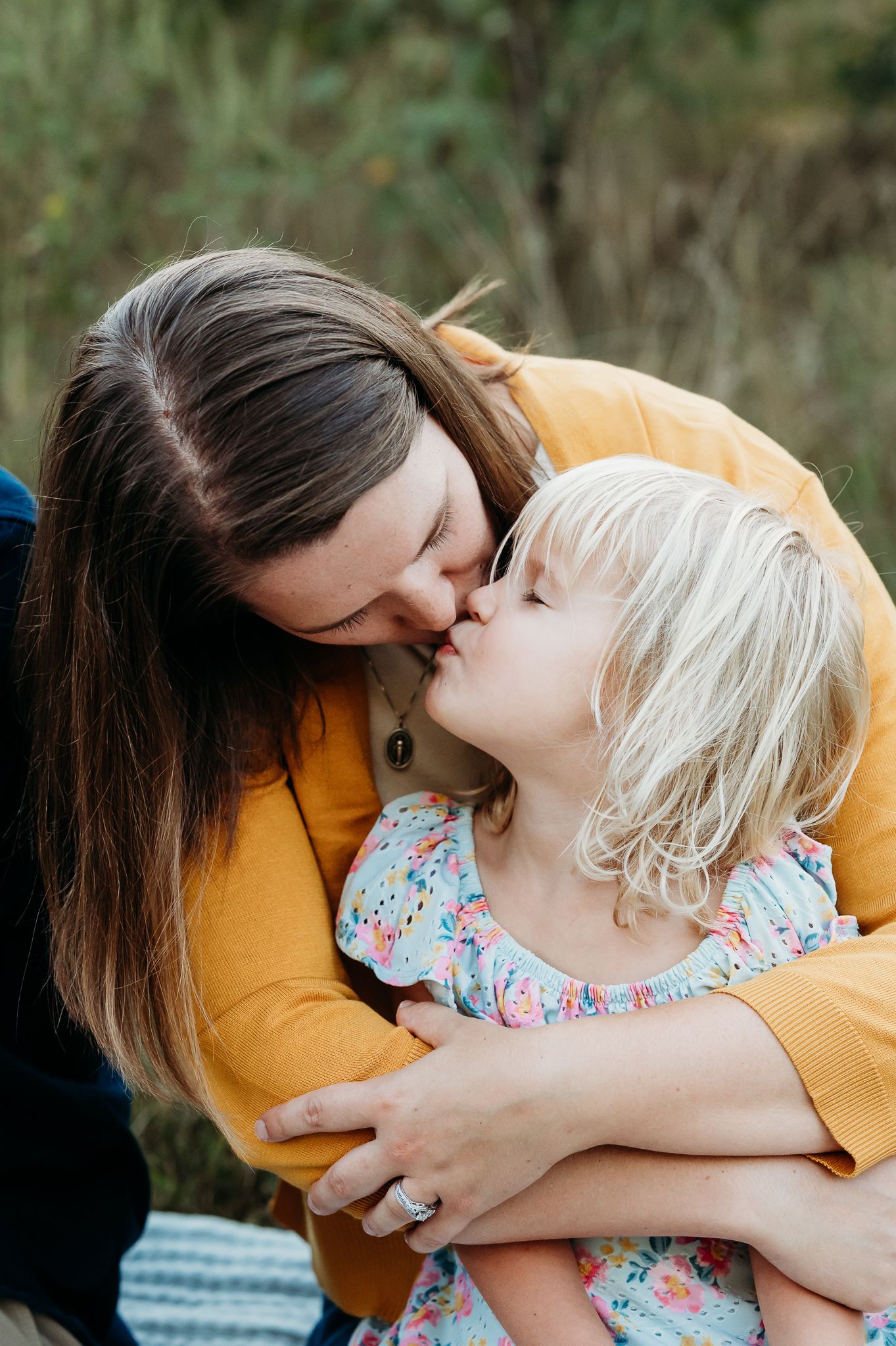 A heartwarming image showing tender moment between mom and daughter during petite family photo session with Sara House Photography in Avon.