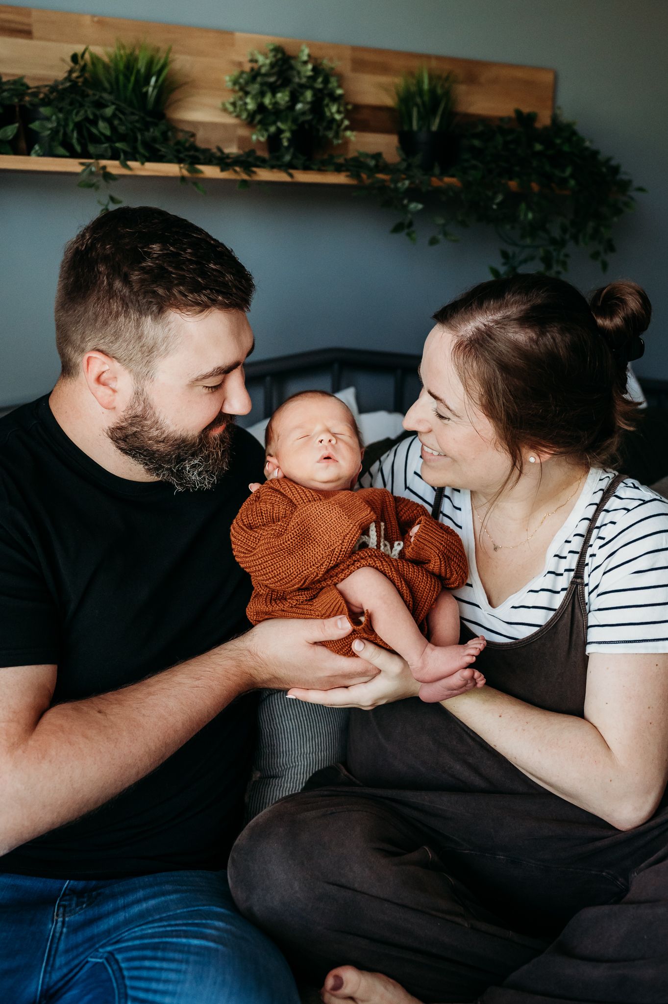 A tender family moment show parents interacting lovingly with their baby in natural lighting during in-home newborn photo session in Indiana