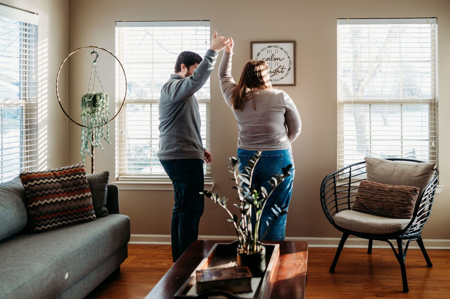 Indianapolis couple dancing together in a cozy living room with hardwood floors and large windows during an in-home photo session.