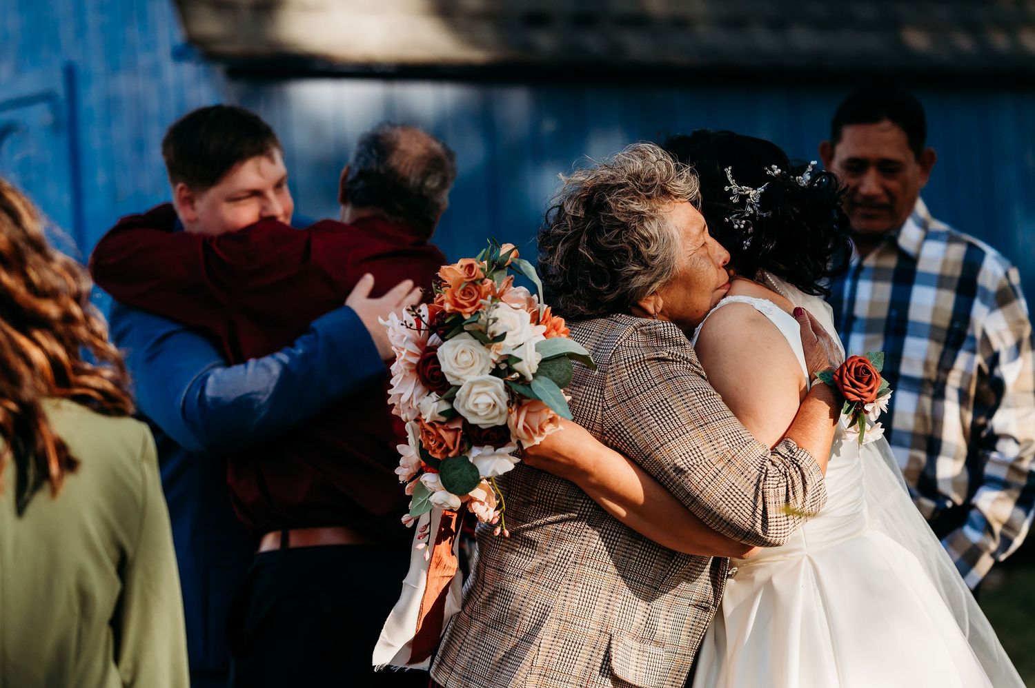 Wedding guests enjoying an outdoor reception with floral arrangements and natural lighting.