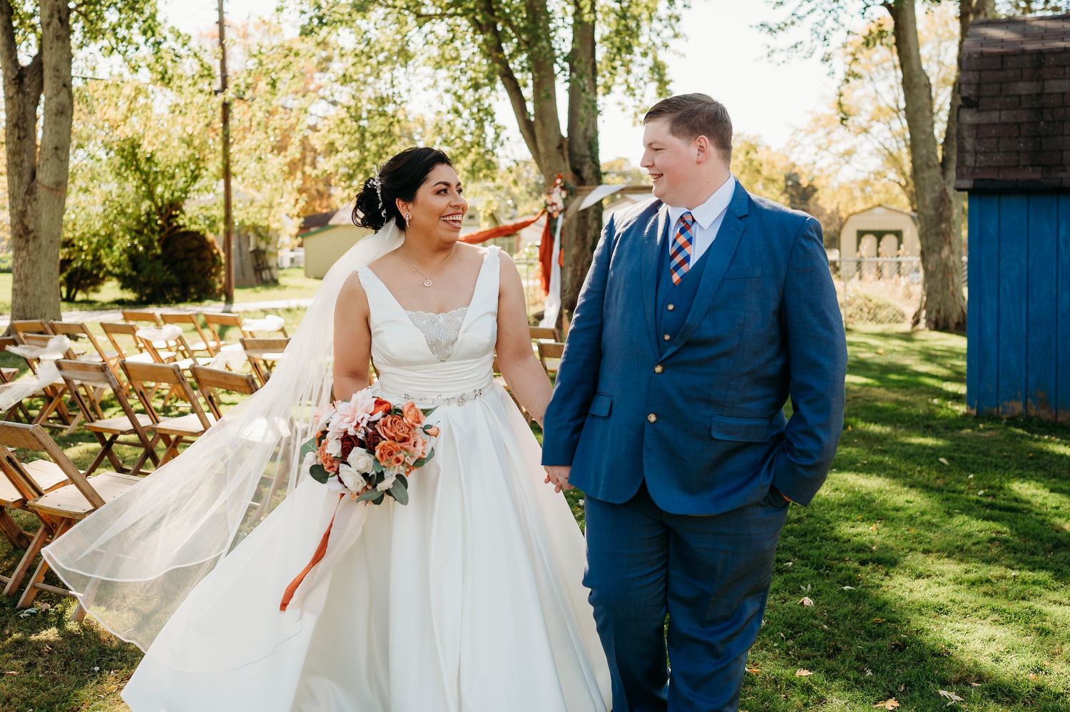 A couple shares romantic moments in a sunlit garden setting during a wedding celebration.