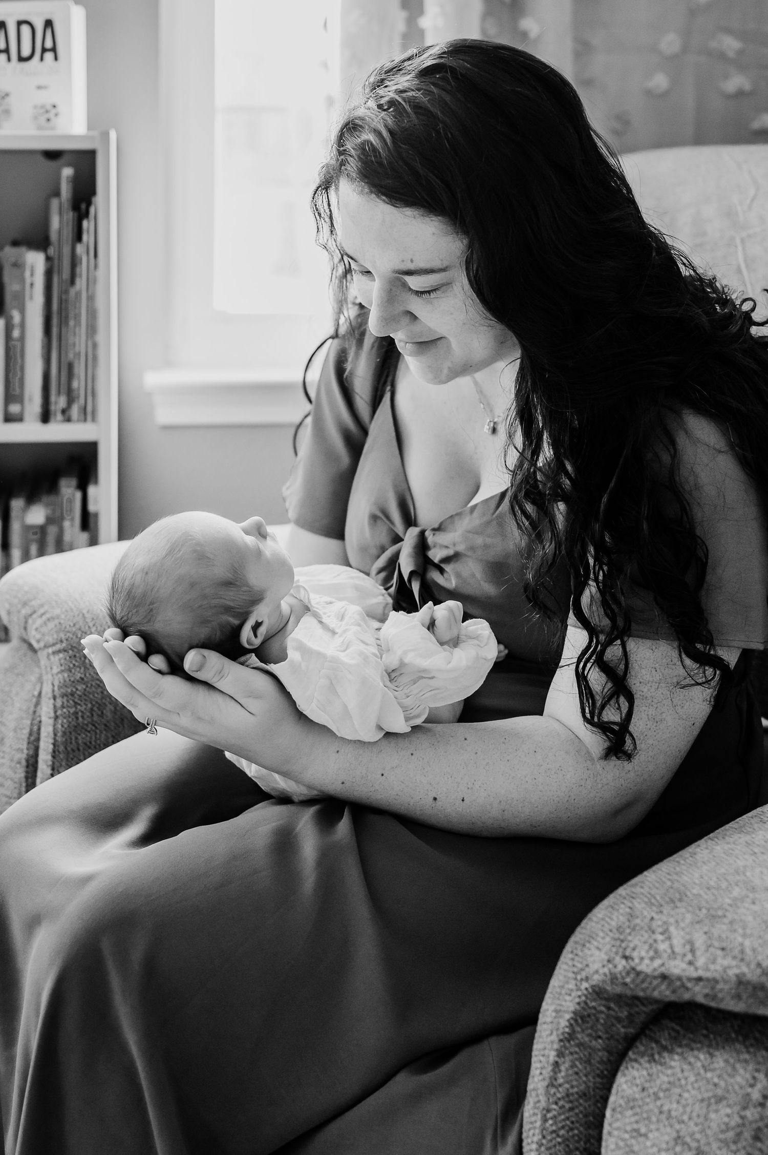 A tender black and white photo series showing intimate moments between parent and newborn baby.