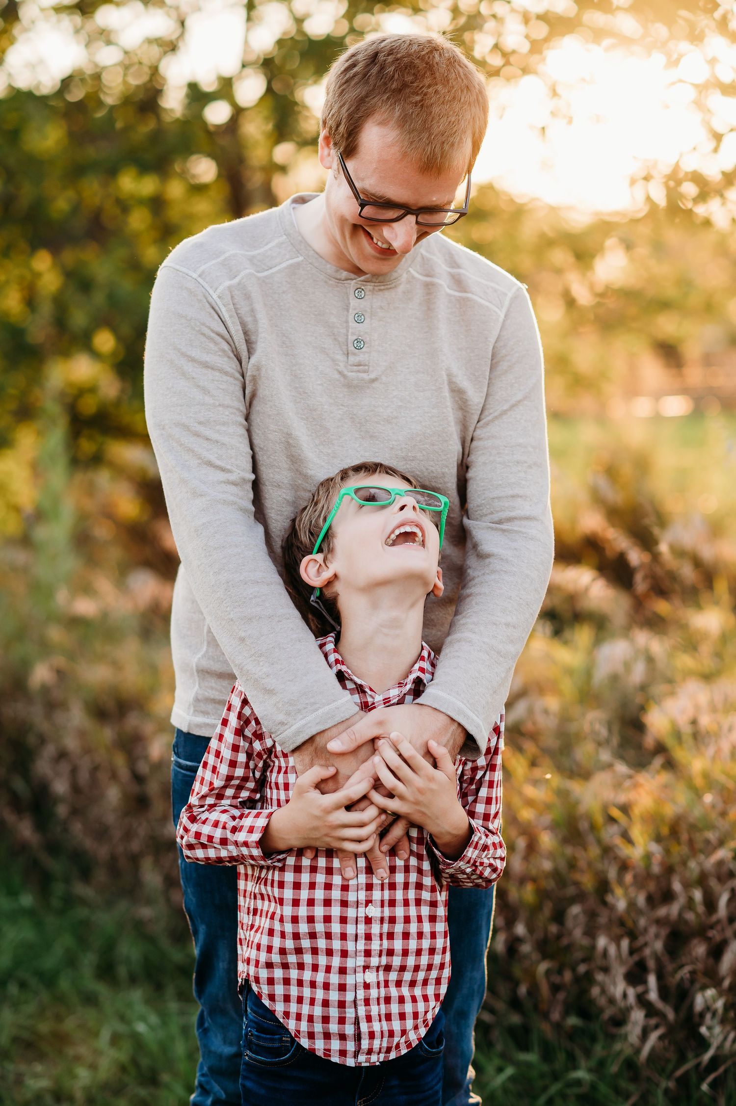 A playful series of photos showing a dad and son laughing and embracing in a sunlit outdoor setting in West Lafayette, Indiana.
