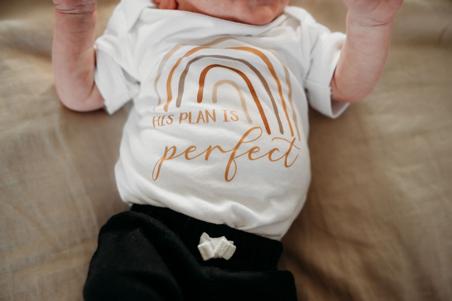 Baby boy white onesie with rainbow in Greenwood home during photo session with Sara House Photography.