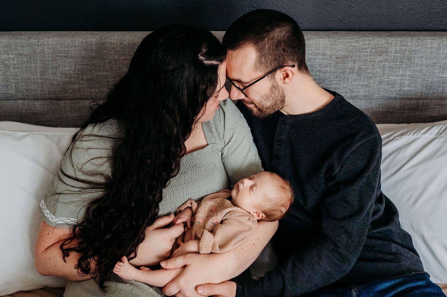 A tender moment between mom, dad, and baby during an in-home newborn session in Noblesville, Indiana.