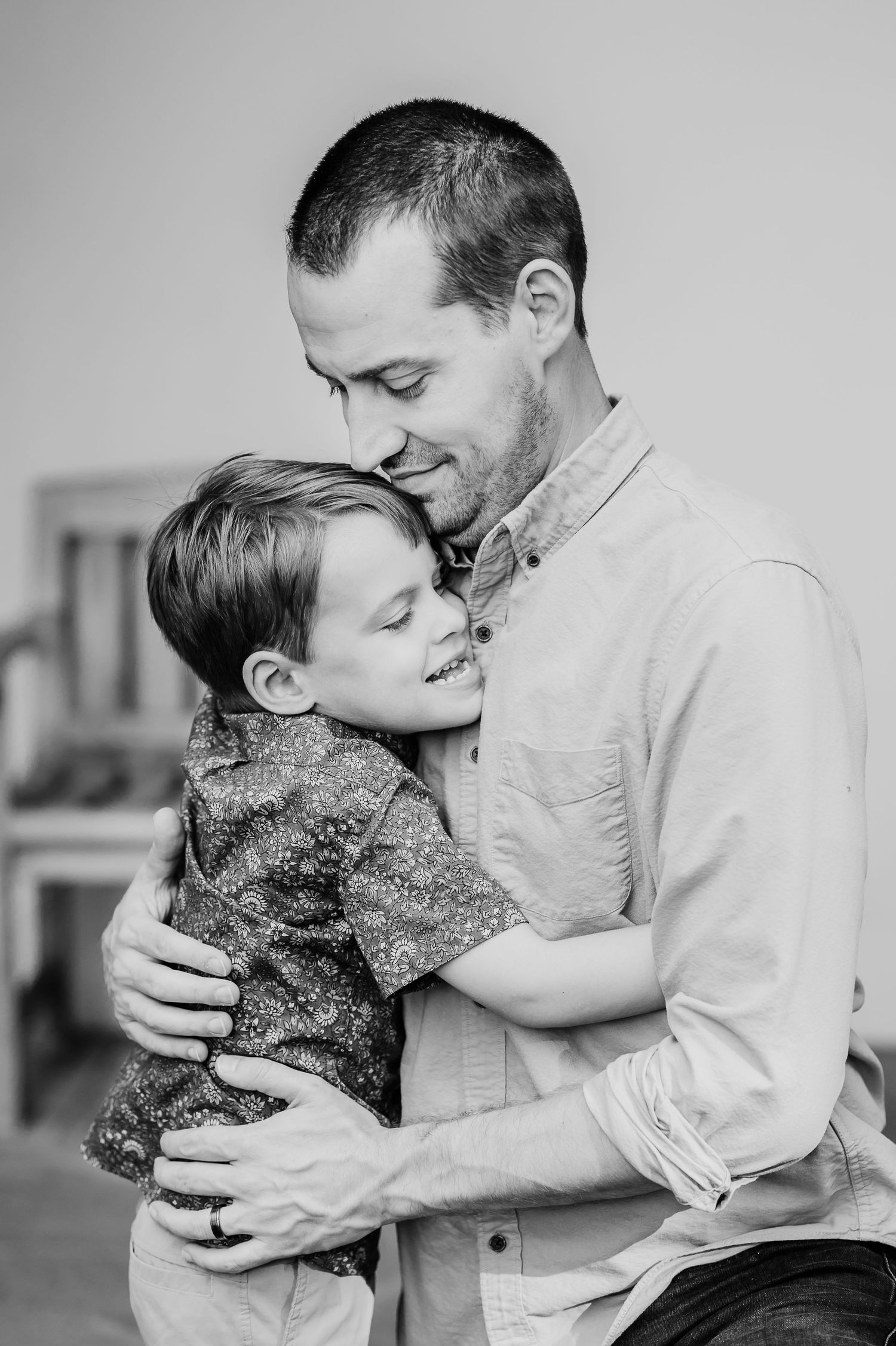 Black and white images of father hugging son during summer family photo session at Newfields in Indianapolis.