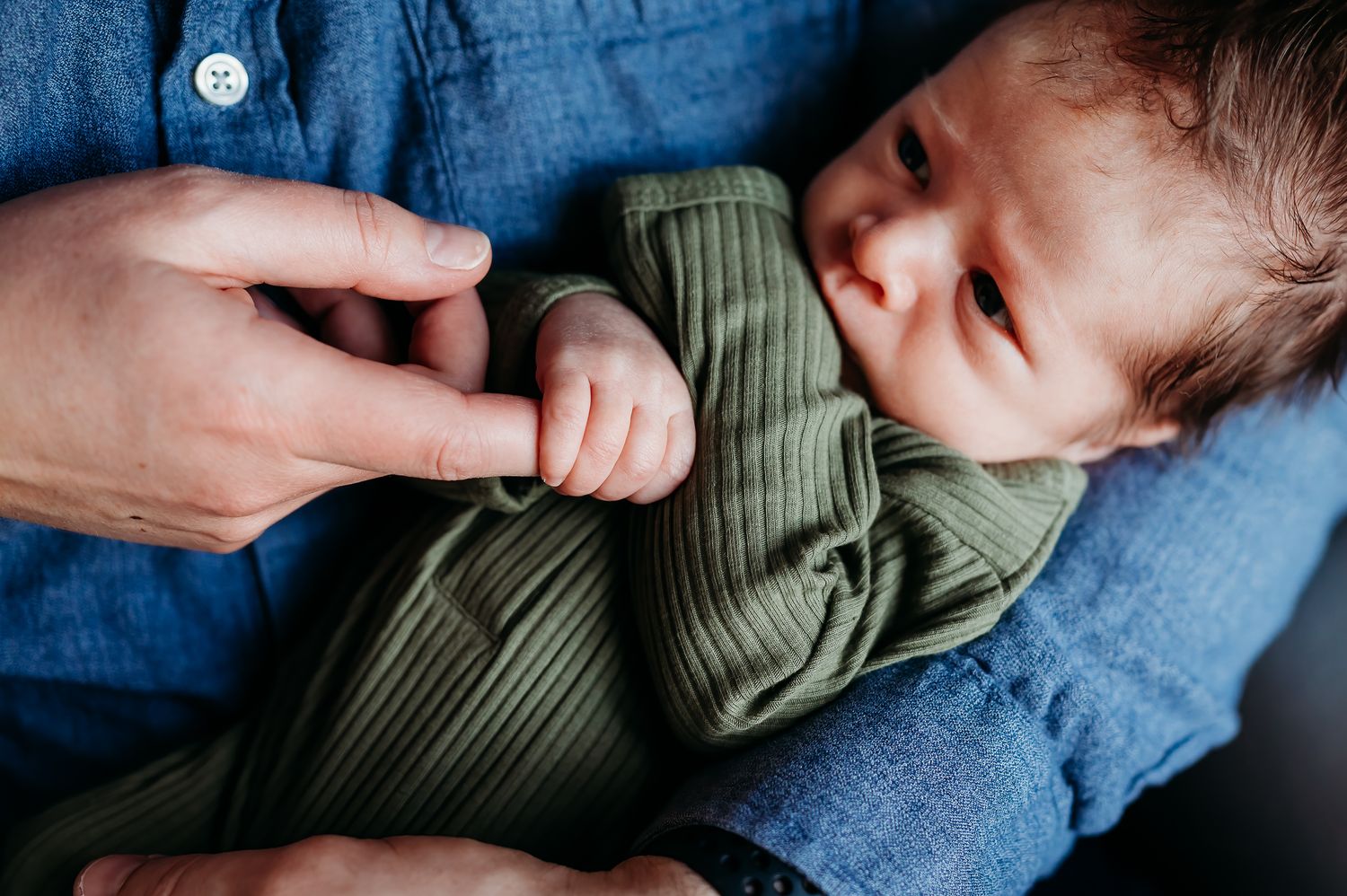 Close-up series showing a sleeping baby in olive green onesie resting against blue bedding.