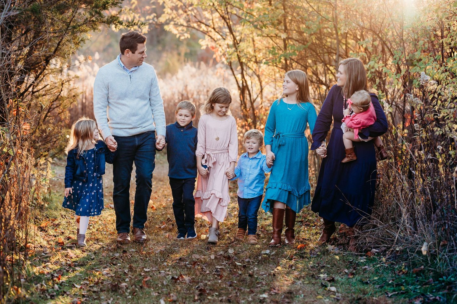 Large family stands together for fall family portraits at Ritchey Woods Nature Preserve in Fishers, Indiana.