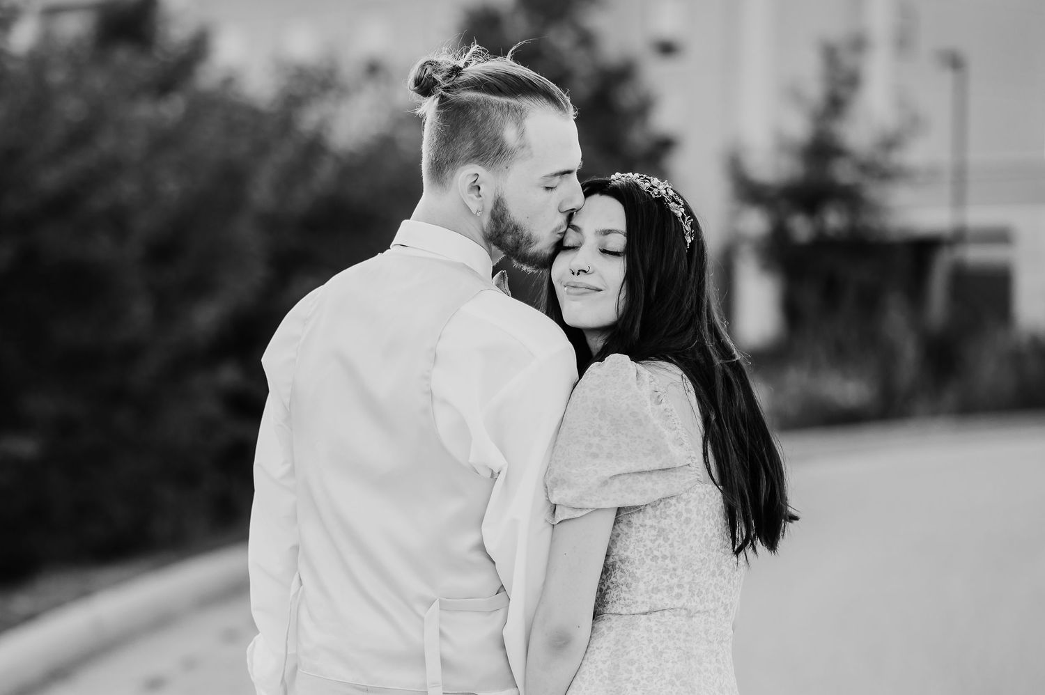 A romantic black and white photo series showing tender moments between a couple in an outdoor setting.