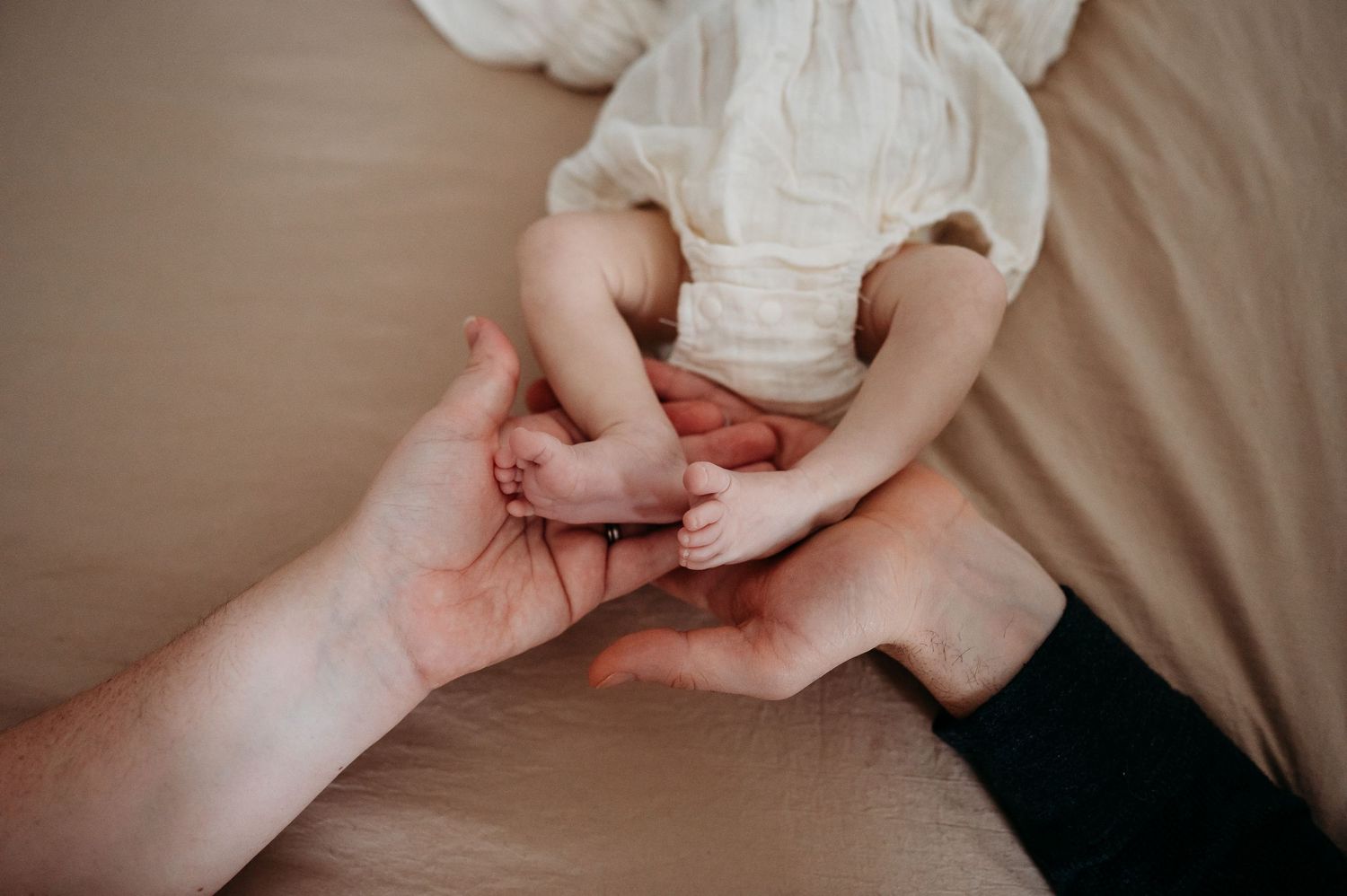 Hands delicately fold a white cloth diaper in a step-by-step sequence showing proper folding technique.