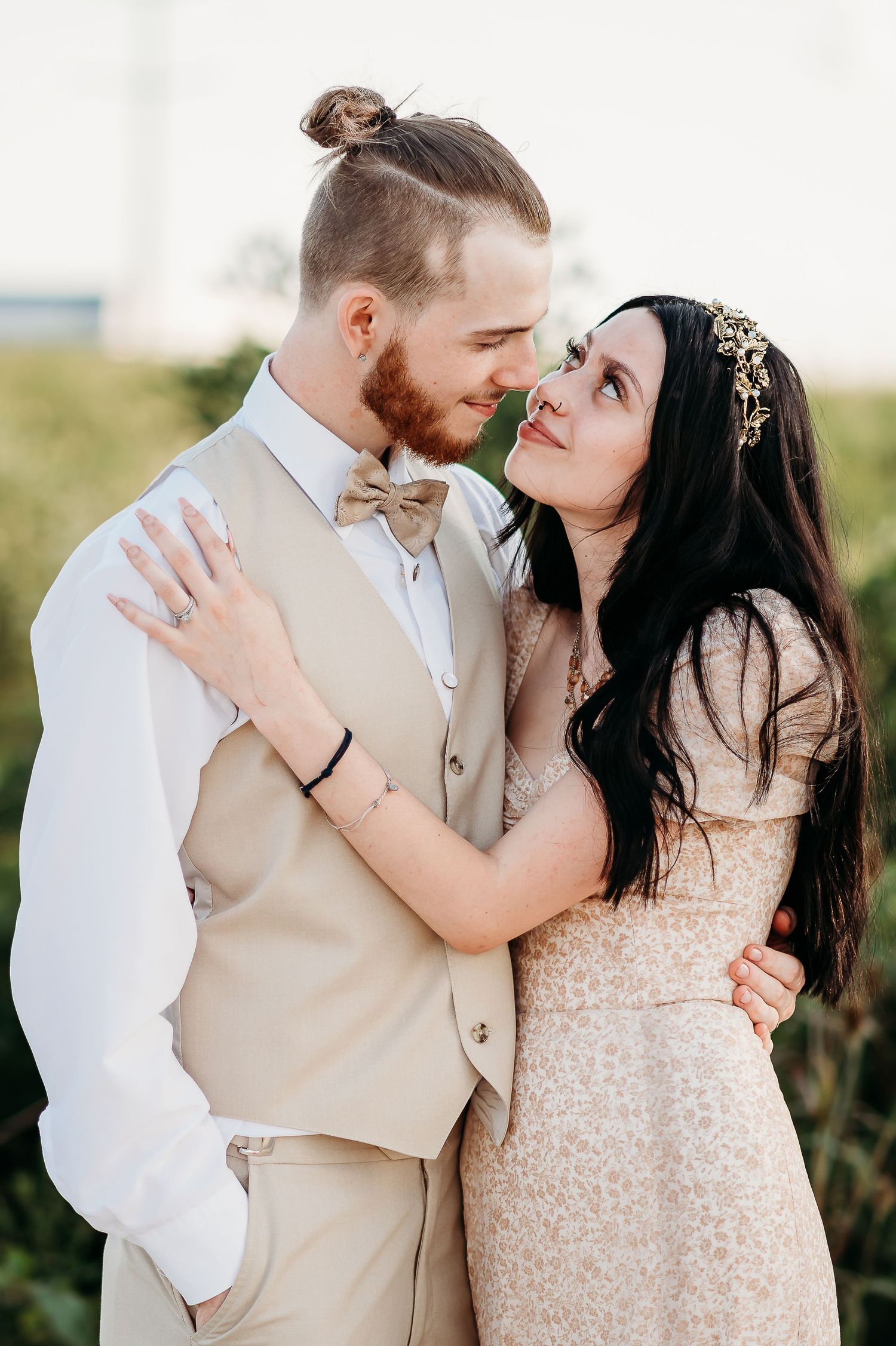 Romantic couple in wedding attire share intimate moments against a natural outdoor backdrop.