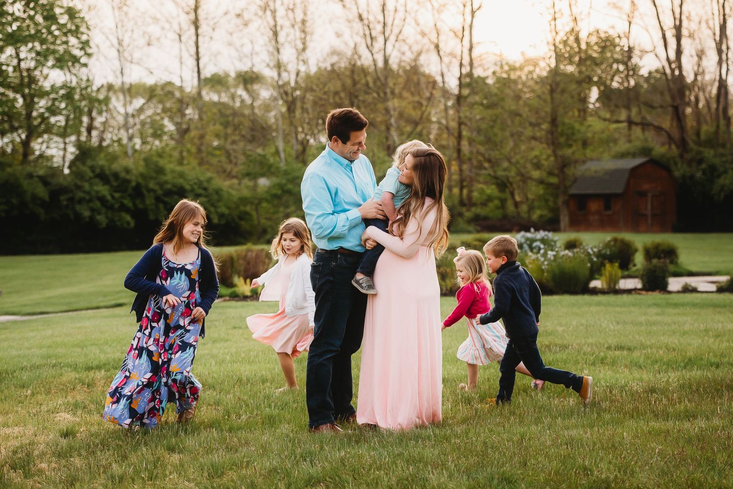 Candid family moments captured during spring maternity photoshoot at Friendship Gardens in Plainfield, Indiana.