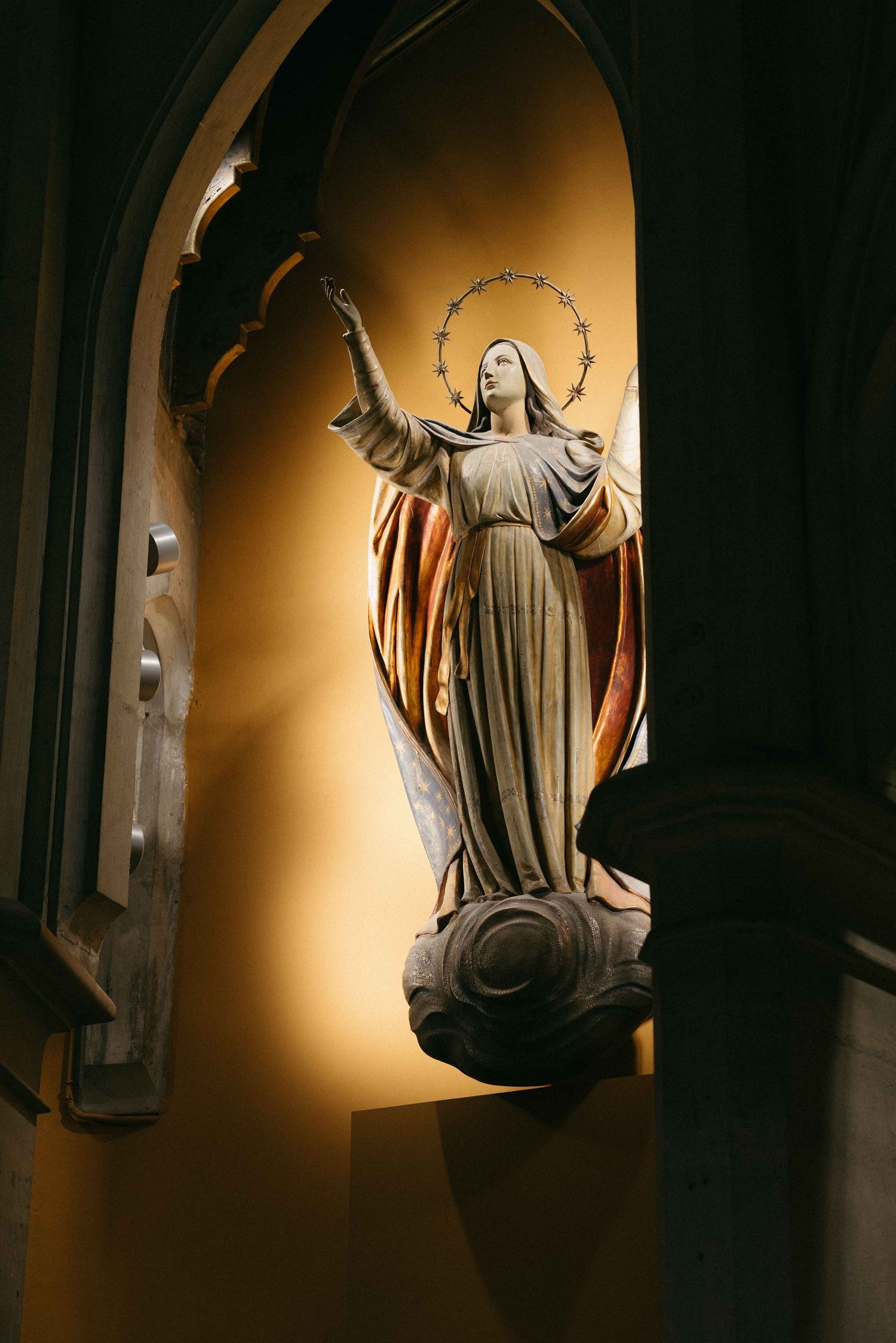 A sequence of photos showing a religious statue illuminated by dramatic lighting against a dark background.