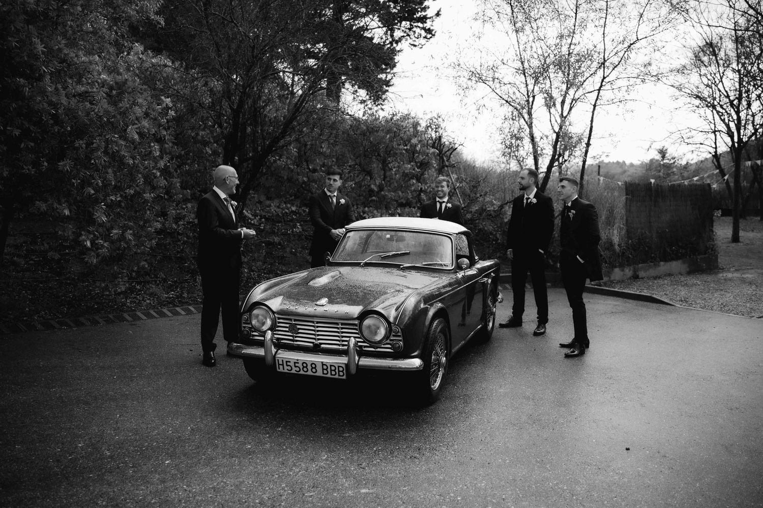 A sequence of vintage black and white photographs showing classic cars parked in various outdoor settings.