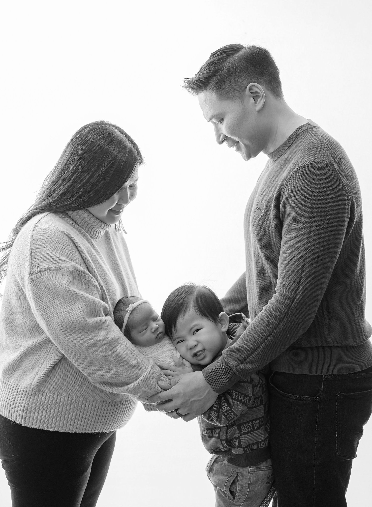 Black and white family portrait showing joyful interaction between parents and child.