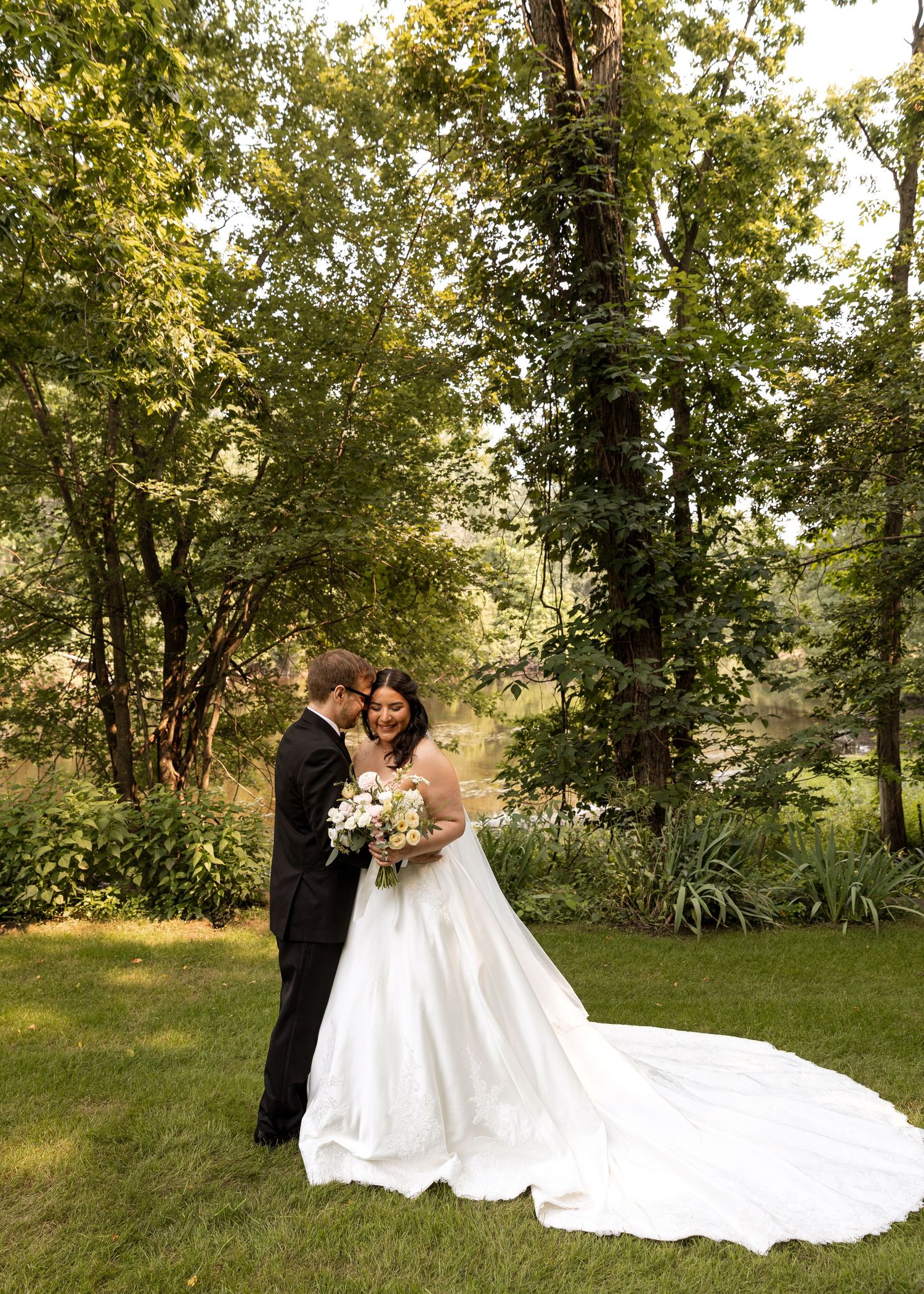 Romantic wedding photos taken in a sunlit garden with a dramatic flowing dress train.