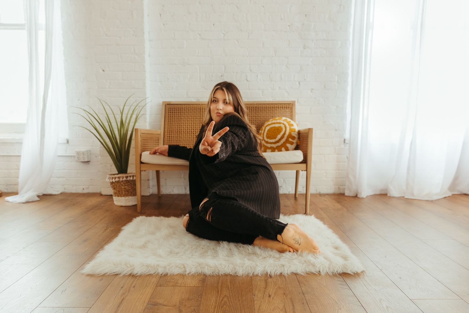 Minimalist photo series showing casual poses on light wooden floor near window.