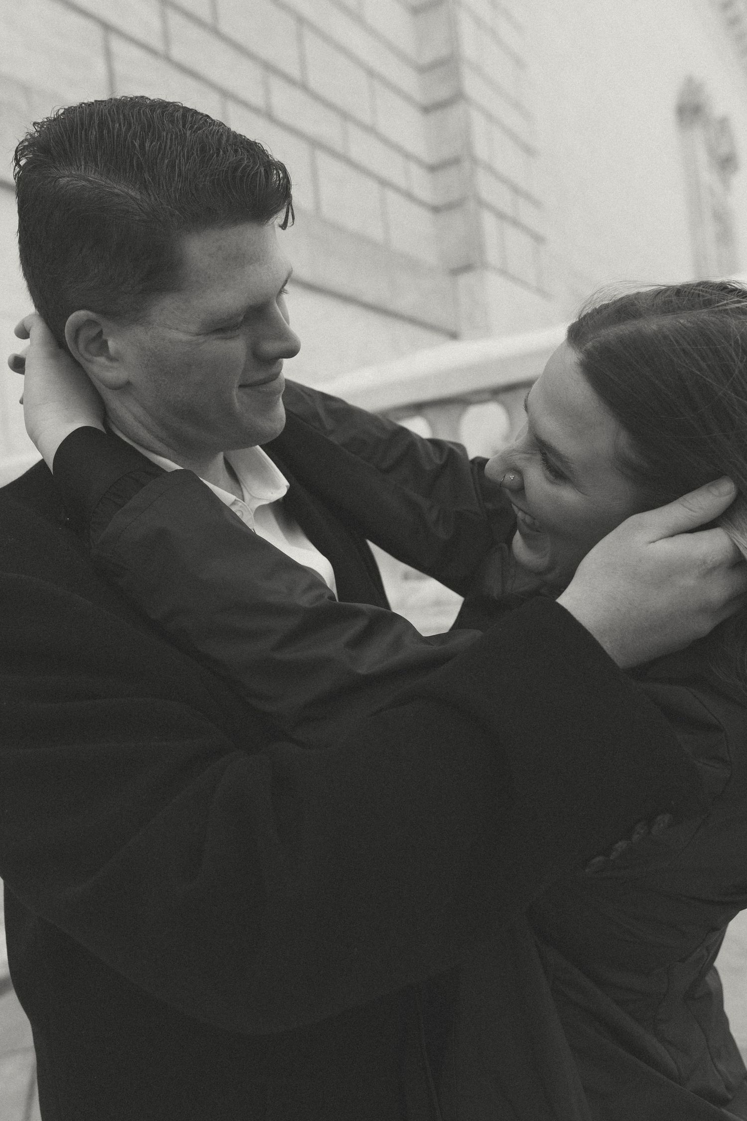 An intimate black and white portrait of a couple sharing a tender moment.