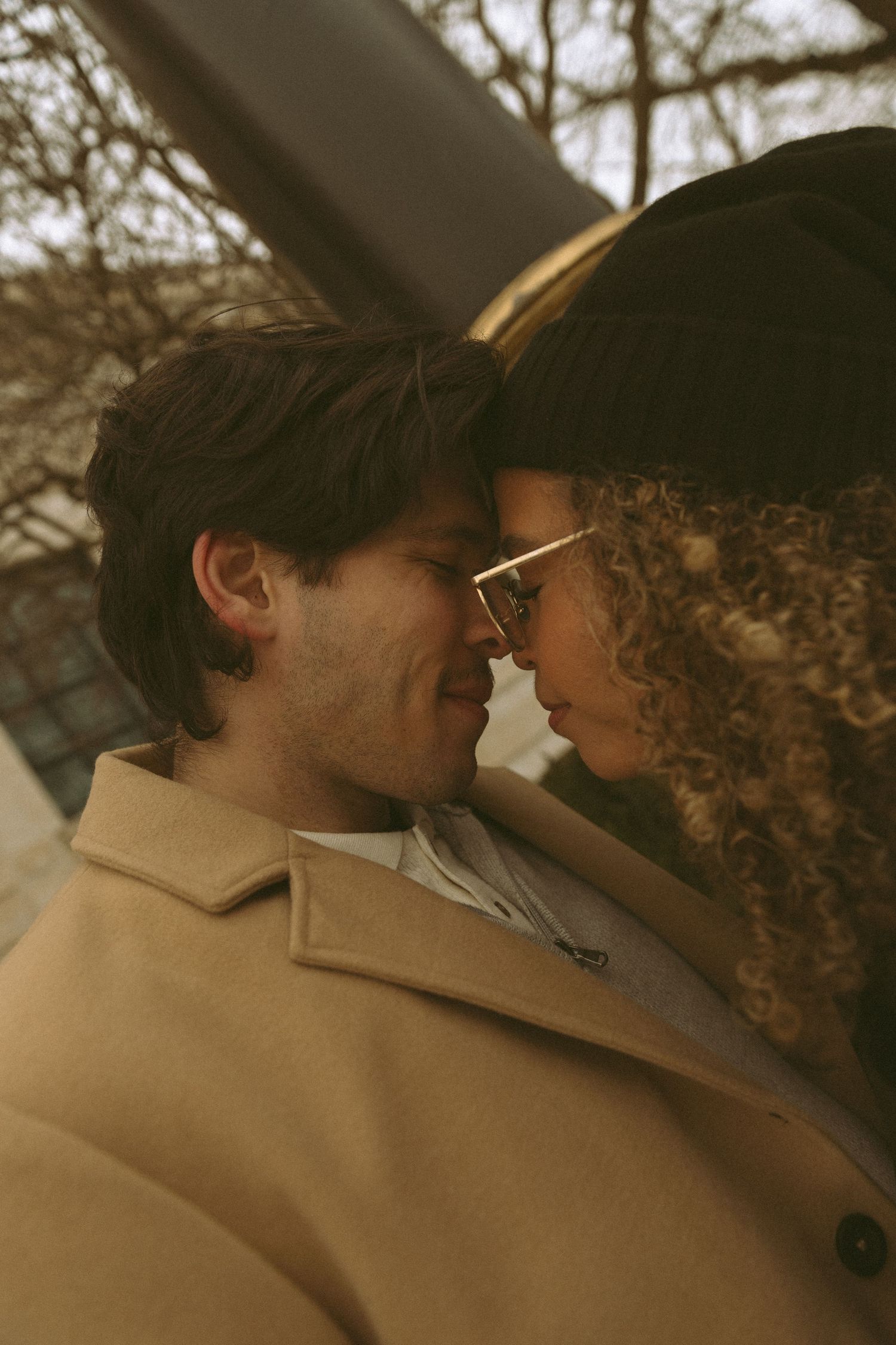 An intimate close-up moment between a couple in warm autumn lighting.