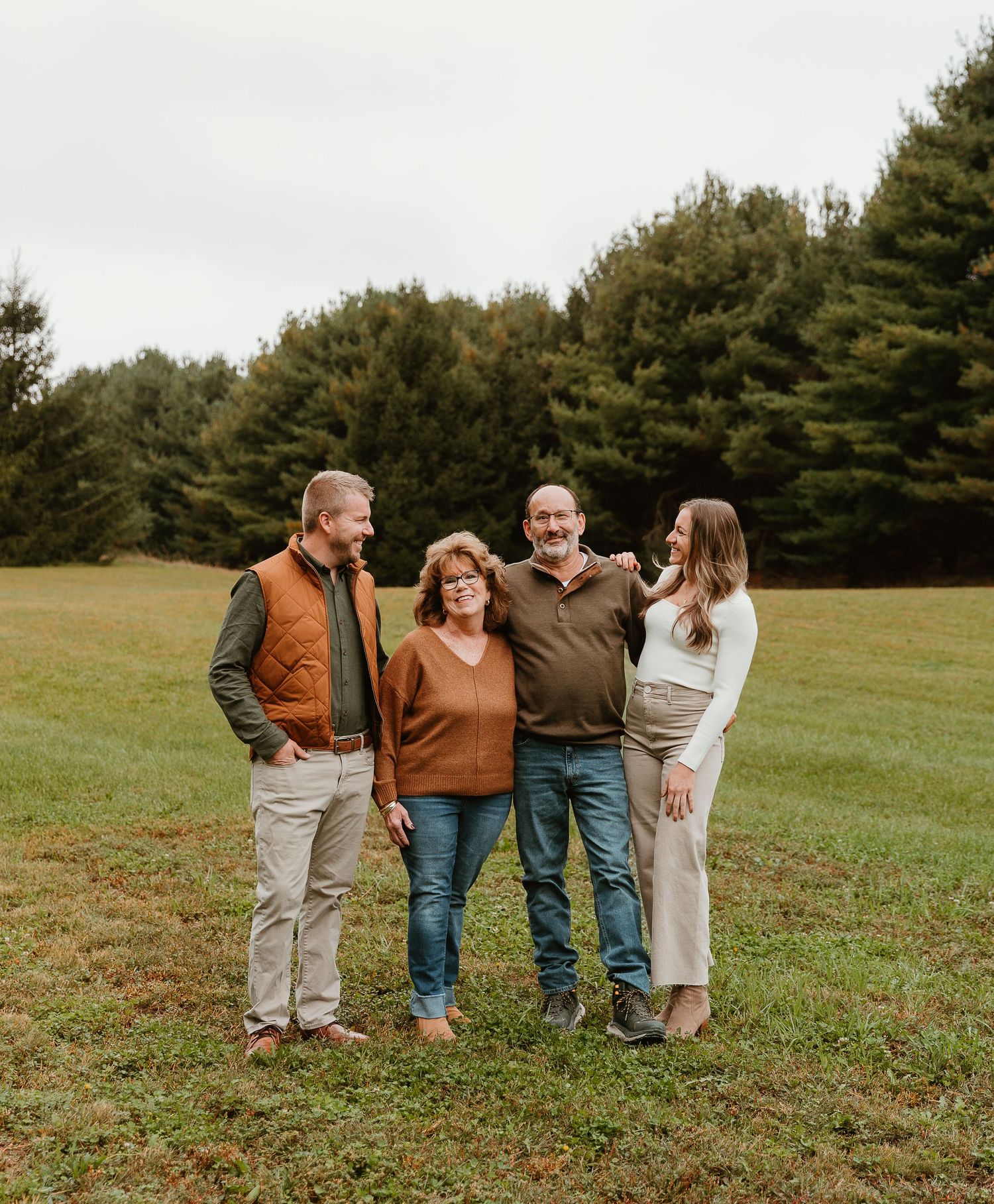 Group gathered together on a green hillside during an autumn photo session.