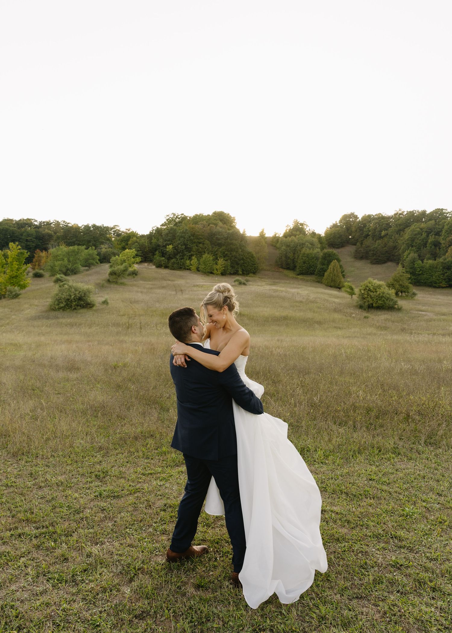 Wedding photo sequence showing a couple dancing playfully in an open field at sunset.