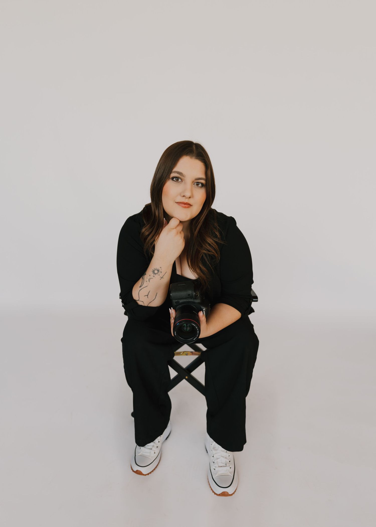 Modern portrait series featuring casual poses in black attire against white backdrop.